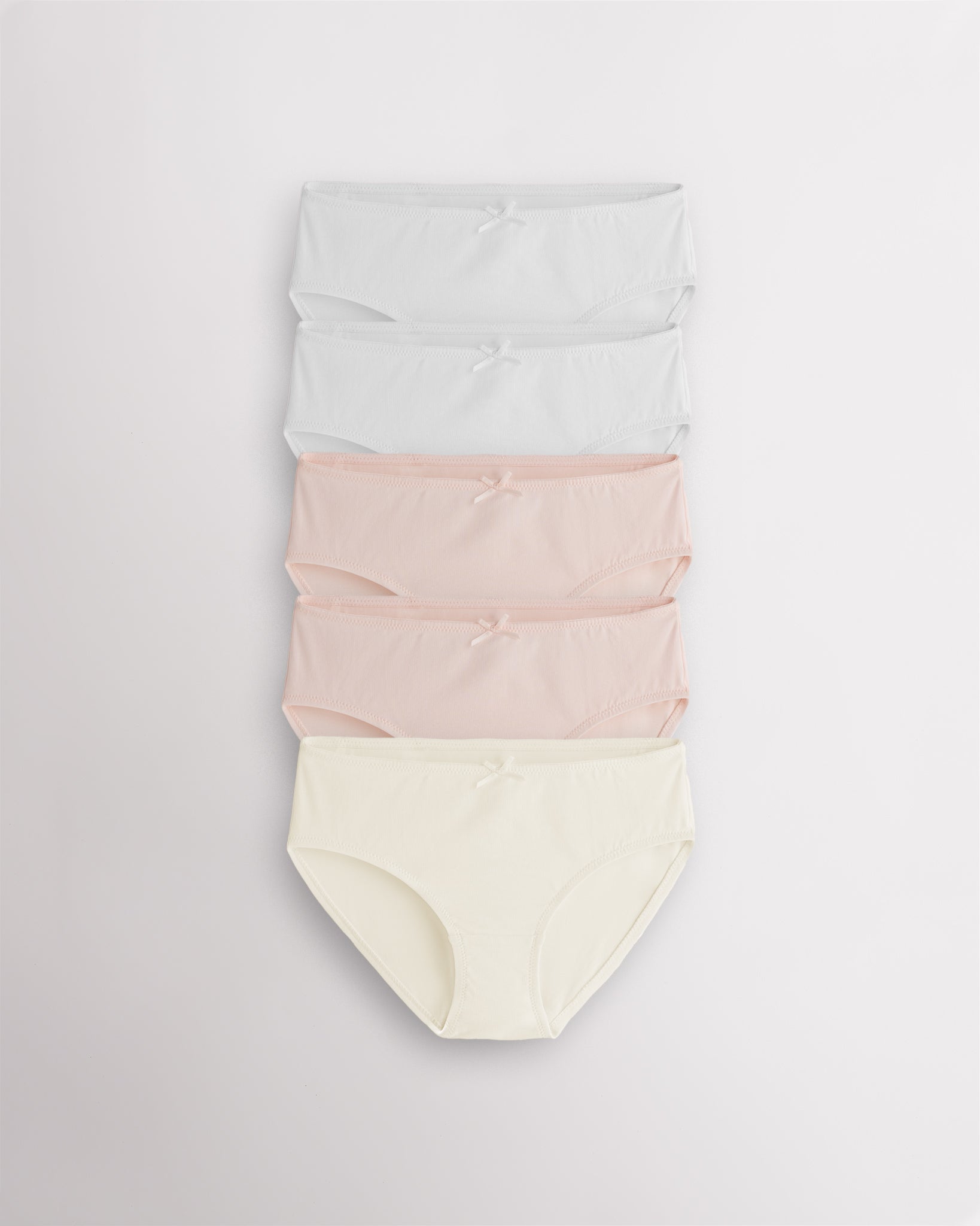 Five-pack pastel girls briefs in white, whisper pink, and soft butter with bow accents and elasticized openings.