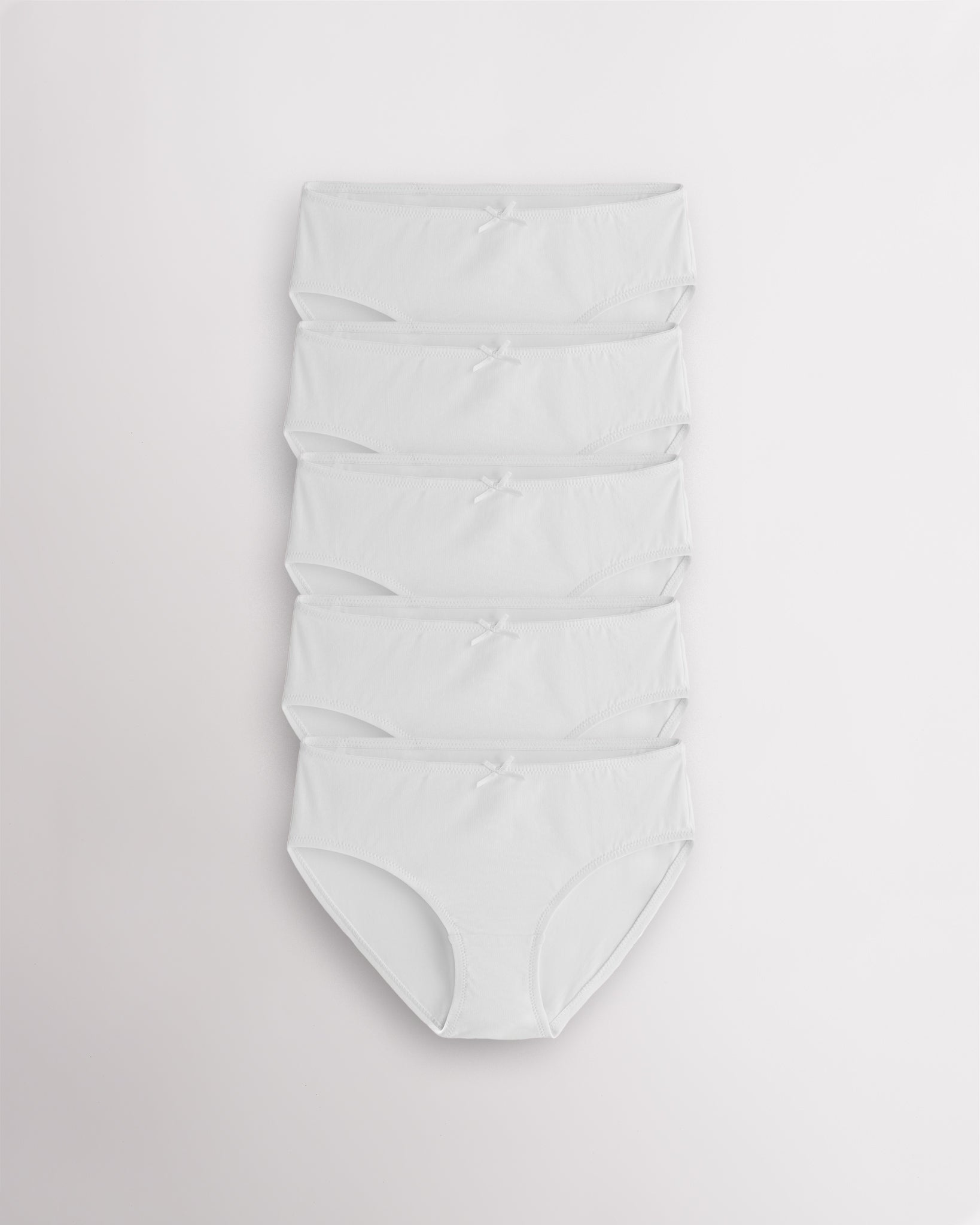 Five-pack white girls briefs with bow accents, elastic waist and leg openings, and soft cotton fabric for everyday girl underwear.