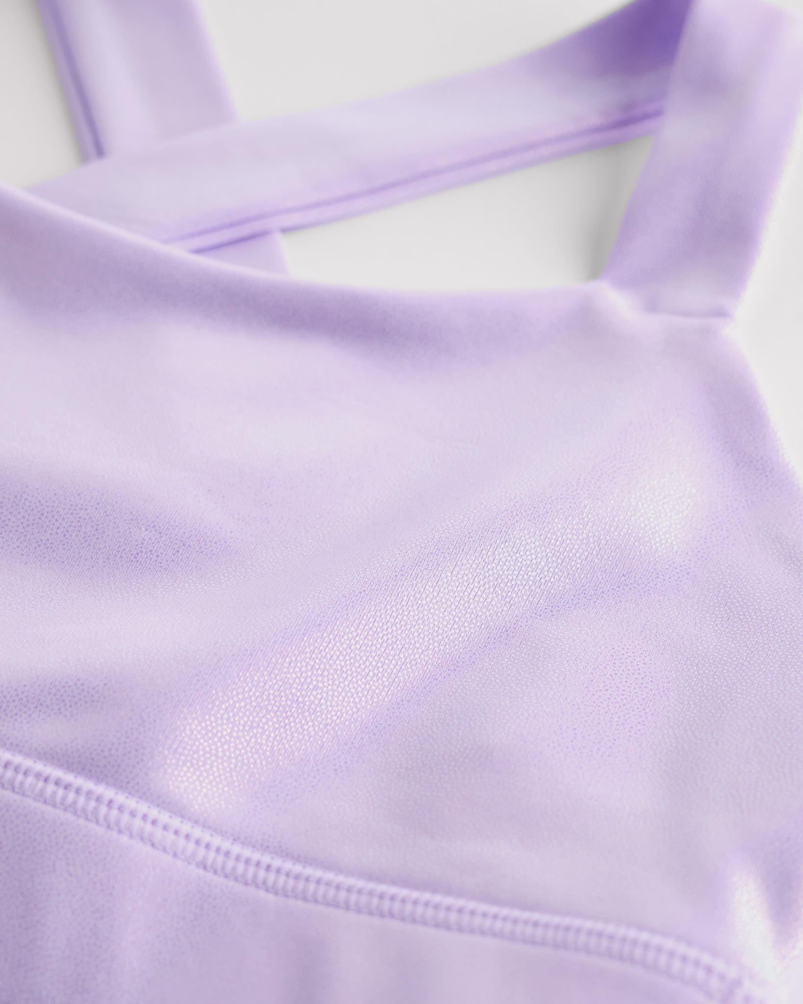 Close-up of lavender metallic girls tank top showing iridescent shimmer fabric and smooth seam detail.