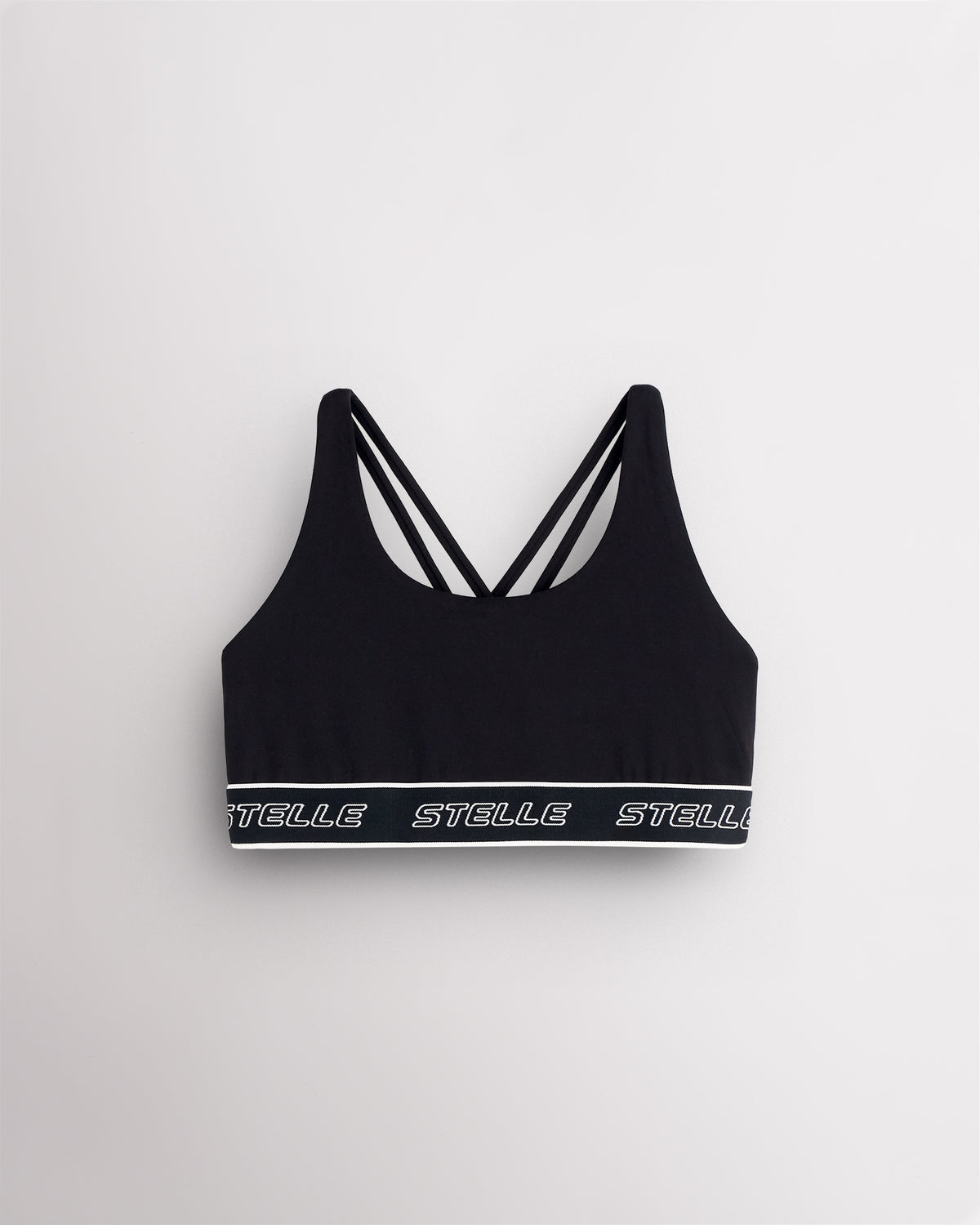 Black Stelle girls sports bra laid flat, showing the scoop neck and logo underband.