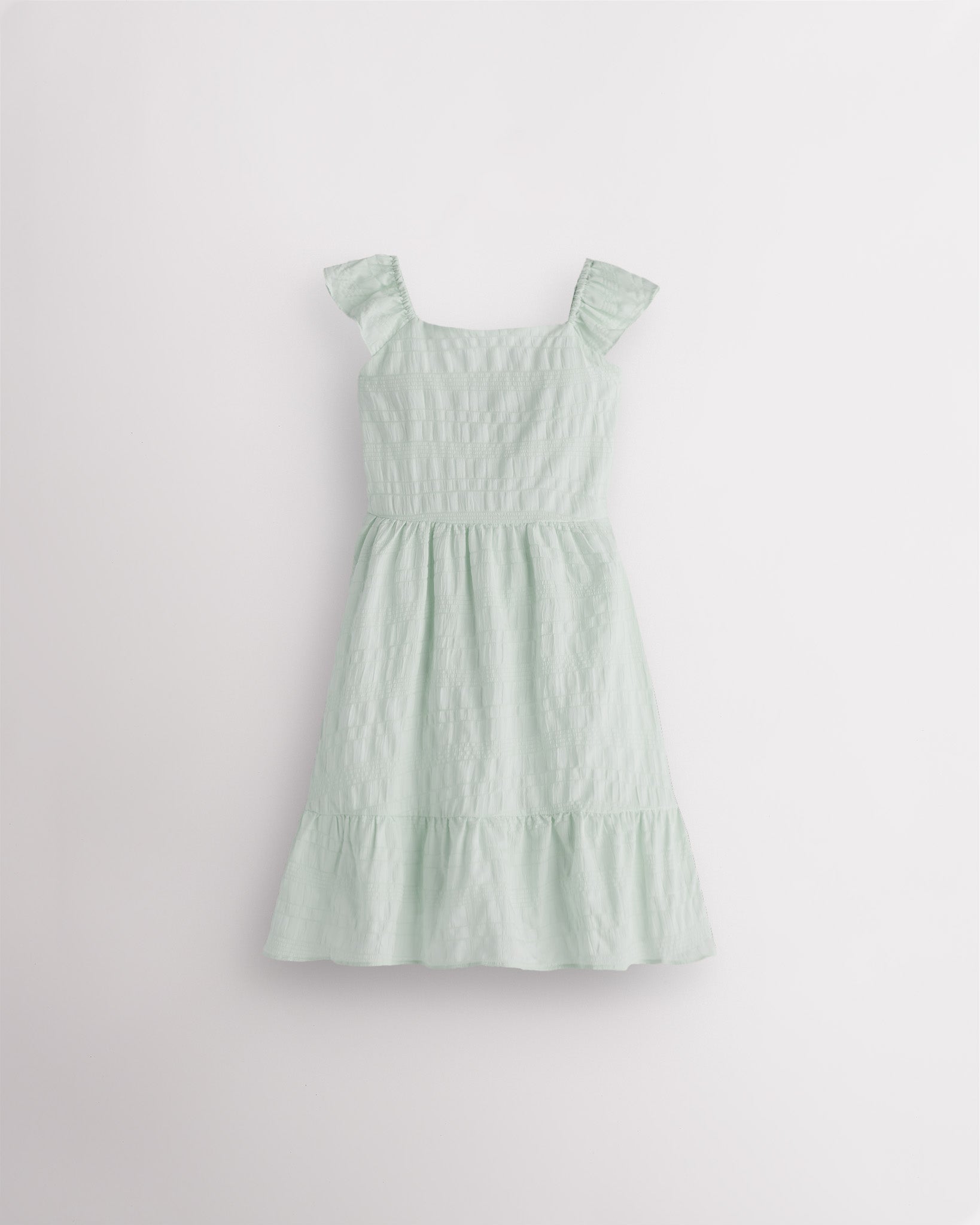 Girls pastel green flutter sleeve sundress with square neckline, smocked waist, and tiered hem, lightweight summer dress front view