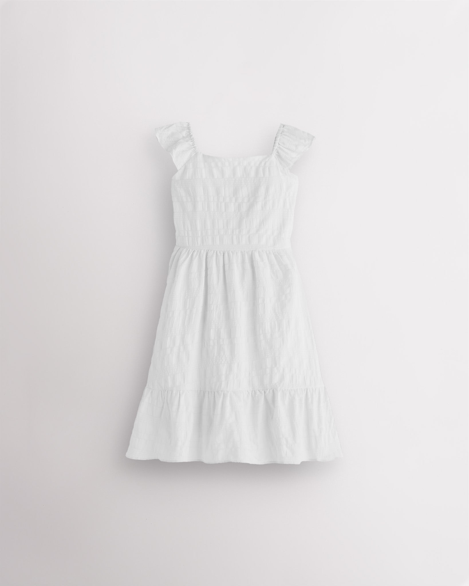 Girls white flutter sleeve sundress with square neckline, smocked waist, and tiered hem, lightweight summer dress front view