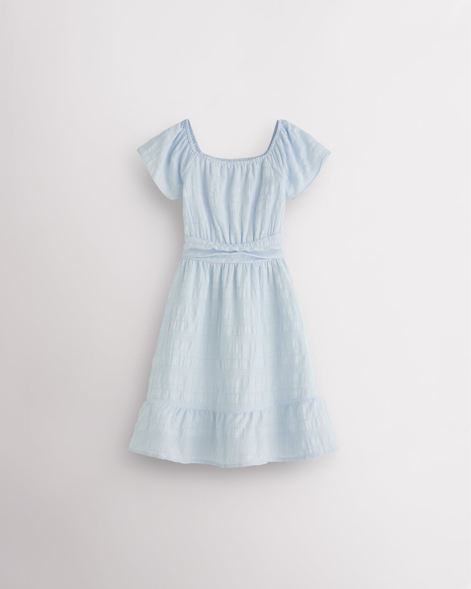 Light blue girls smocked summer dress with short sleeves, square neck, fit-and-flare shape, and ruffle hem.