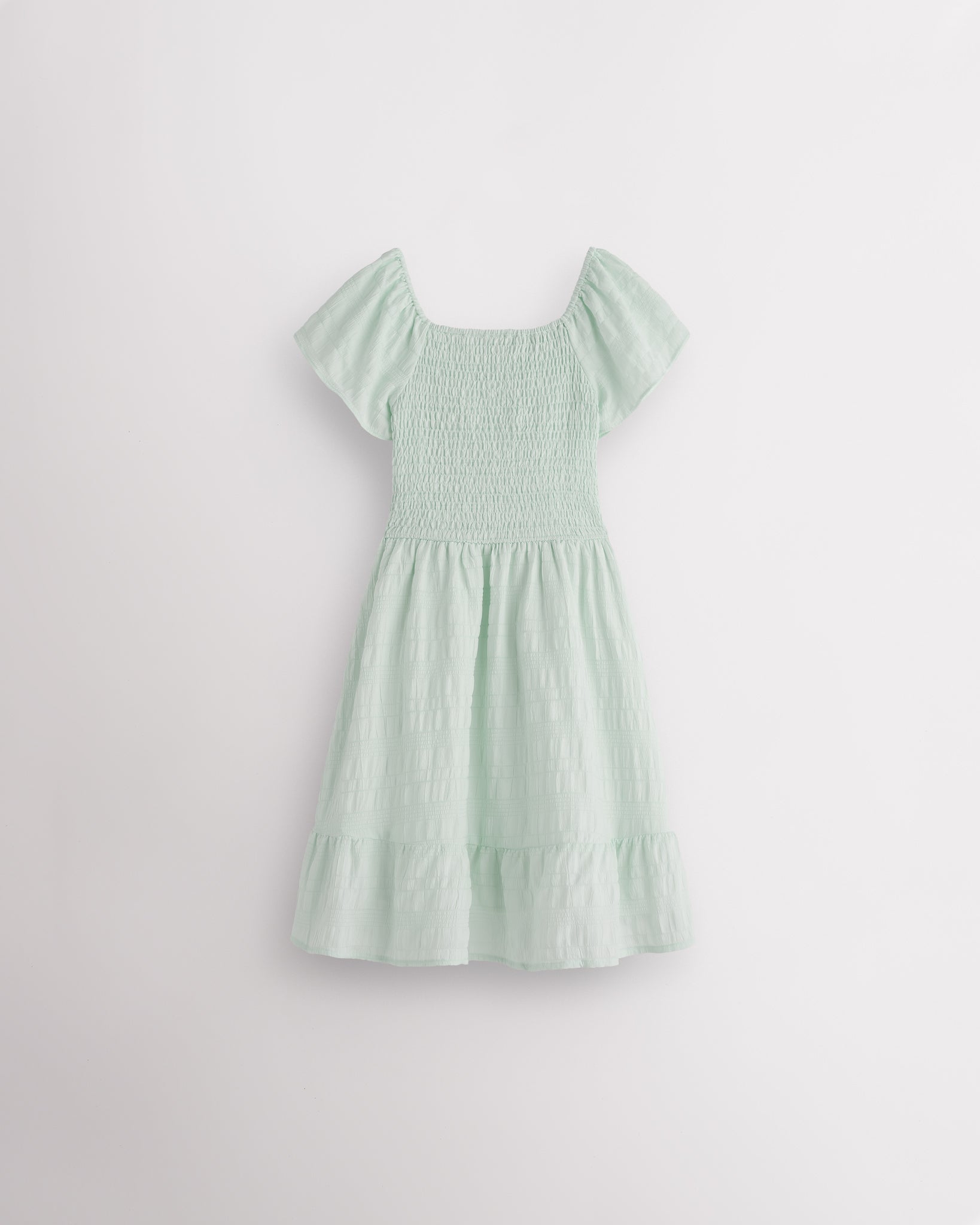 Back view of Pastel Green girls summer dress showing smocked back, short sleeves, and soft gathered skirt.