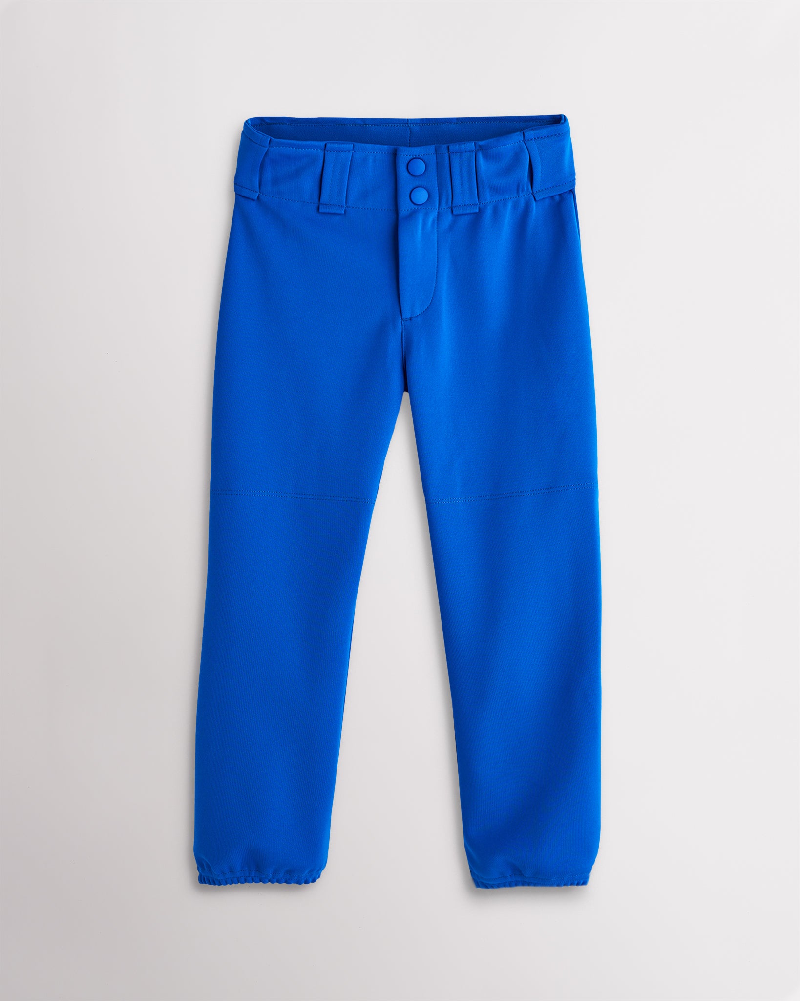 Girls blue softball pants with a tapered fit, belt loops, elastic cuffs, and reinforced knee panels.