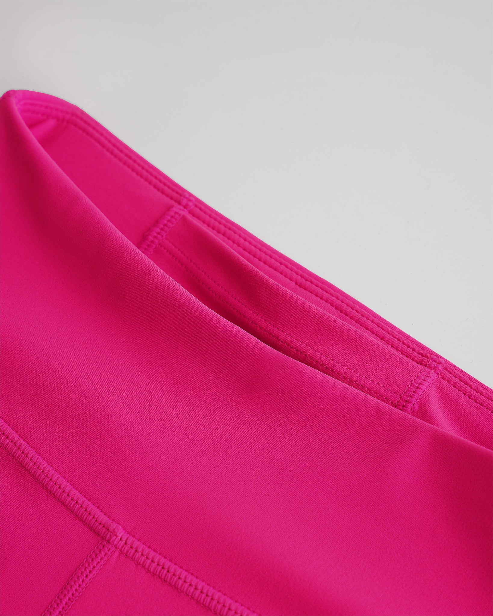 Close-up of hot pink girls yoga leggings showing smooth fabric and high-rise waistband with hidden pocket