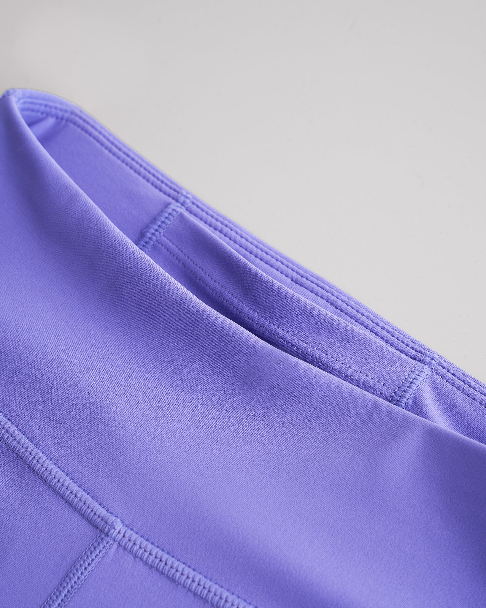 Close-up of periwinkle girls yoga leggings showing smooth fabric and high-rise waistband with hidden pocket