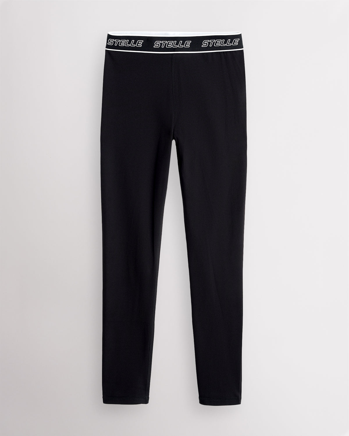 Black Stelle girls leggings laid flat, showing the full-length cut and logo waistband.