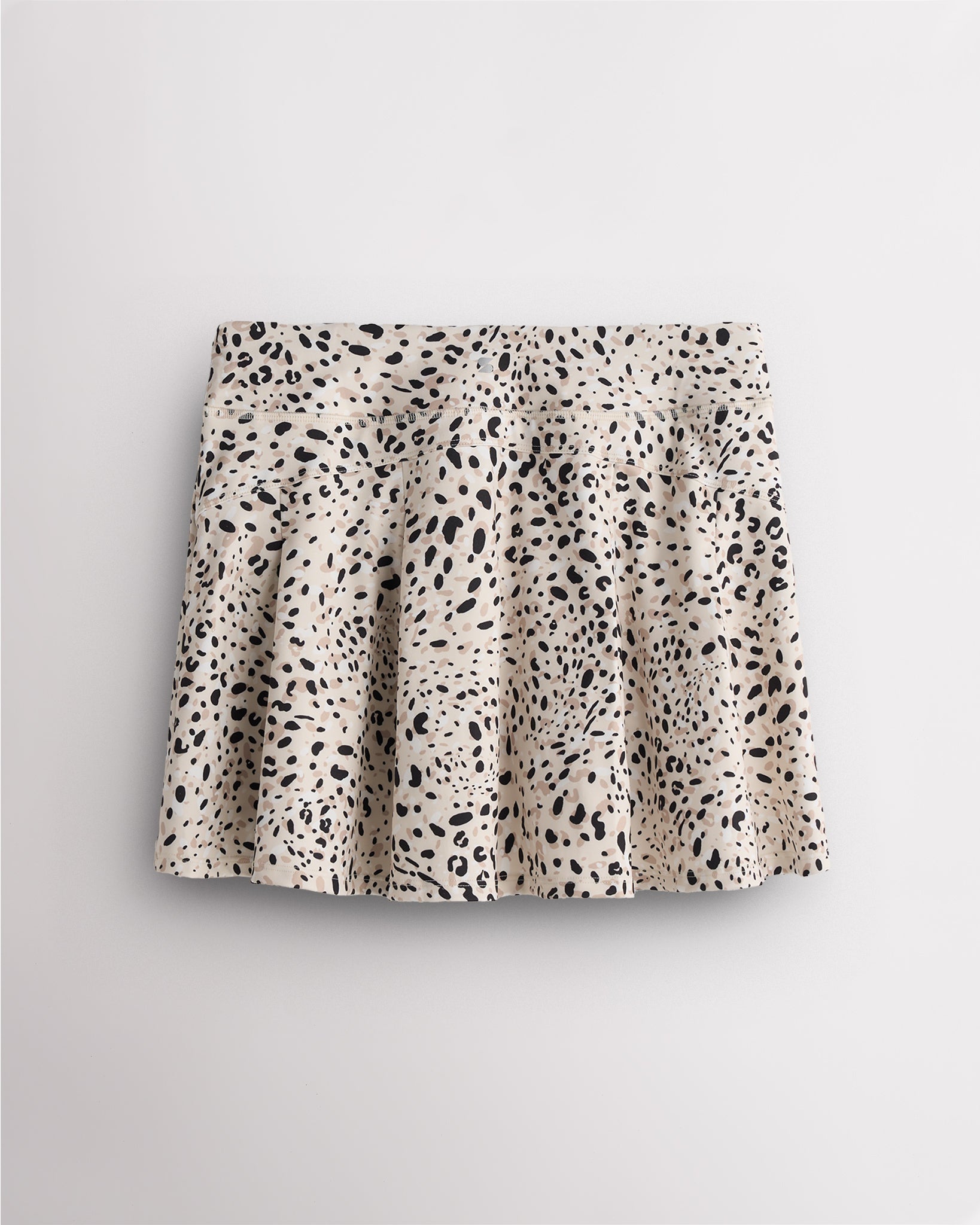 Back view of pleated tennis skirt in white cheetah showing flared silhouette