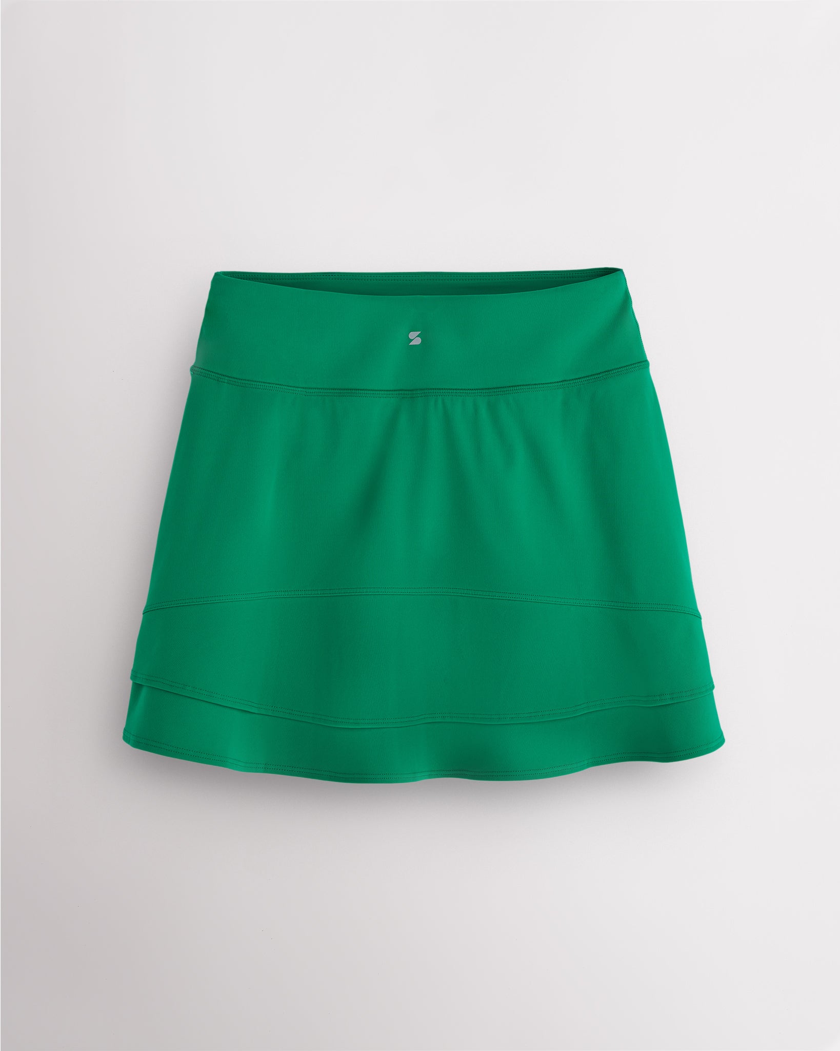 Back view of kelly green Stelle Ruffle Ace tennis skirt showing double-layer ruffle detail, high waistband, and Stelle logo.