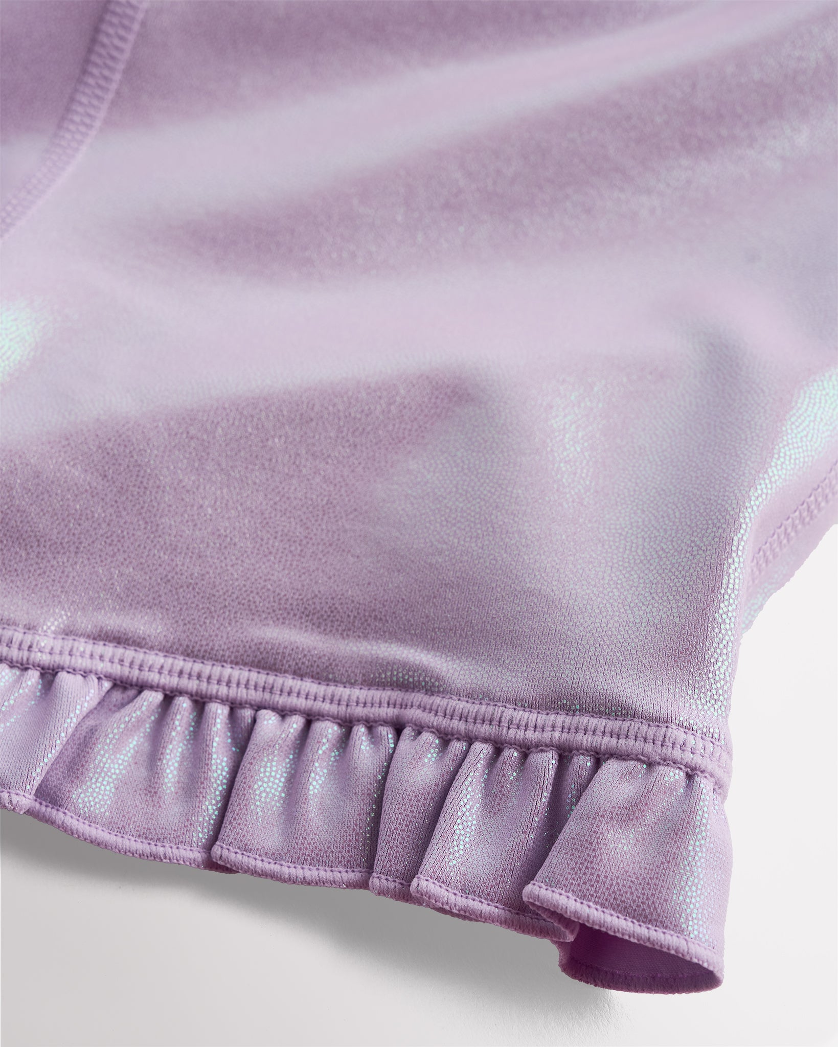 Close-up of lavender shimmer active shorts showing iridescent fabric and ruffle hem detail