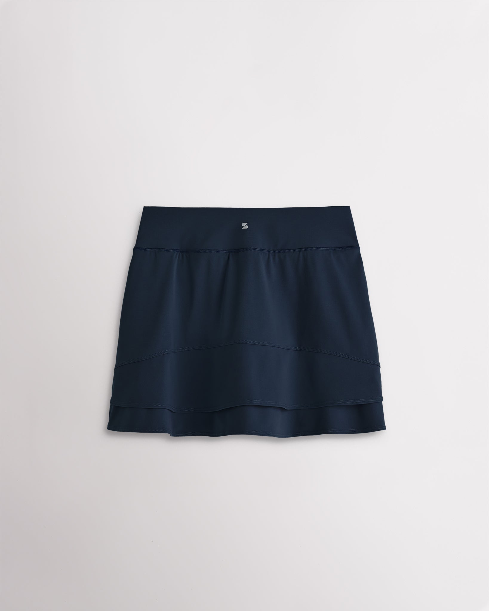 Back view of navy girls tennis skirt with layered ruffle design and built-in shorts for comfort and coverage