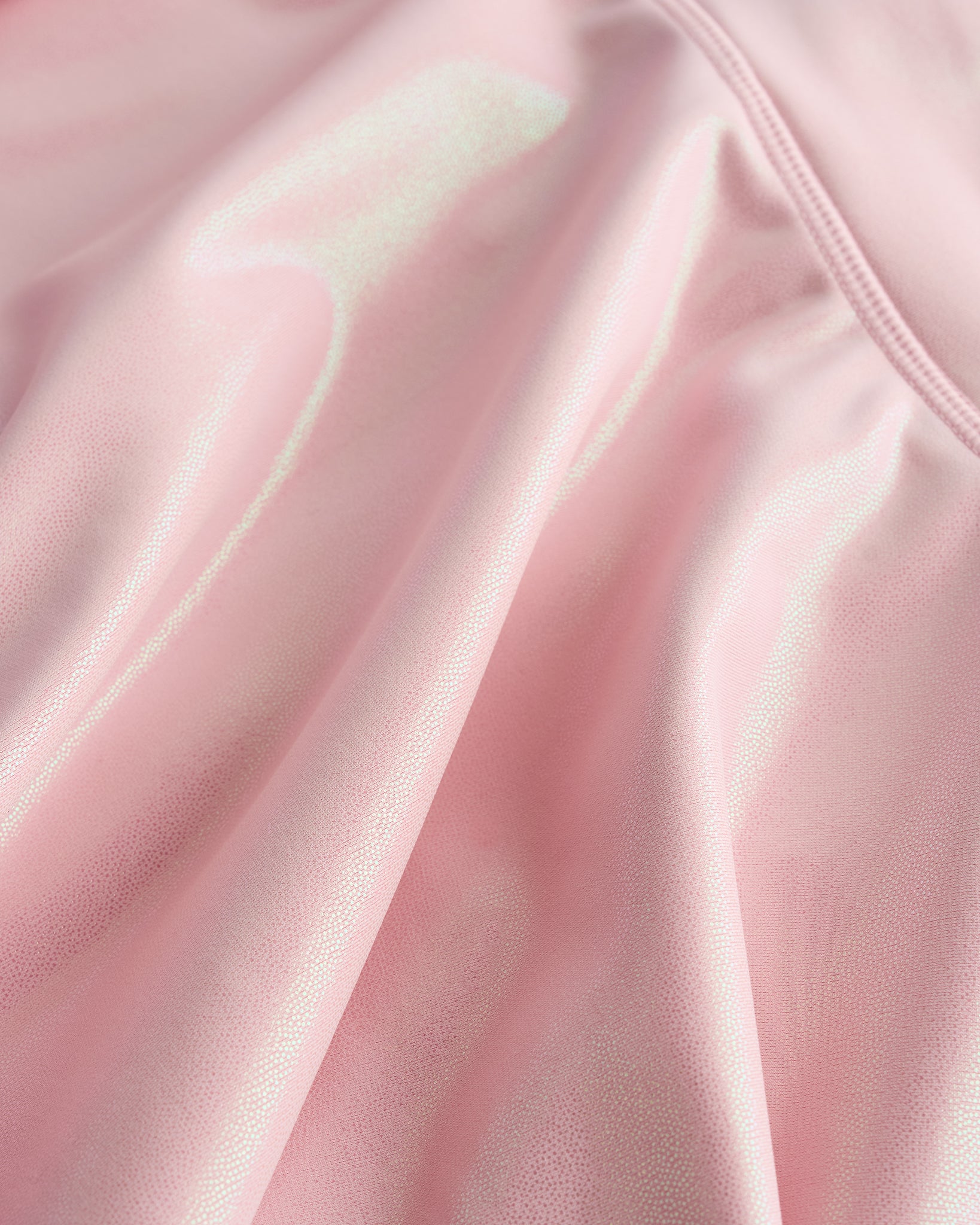 Close-up of pink Stelle girls shimmer skort showing iridescent fabric texture and smooth seam detail