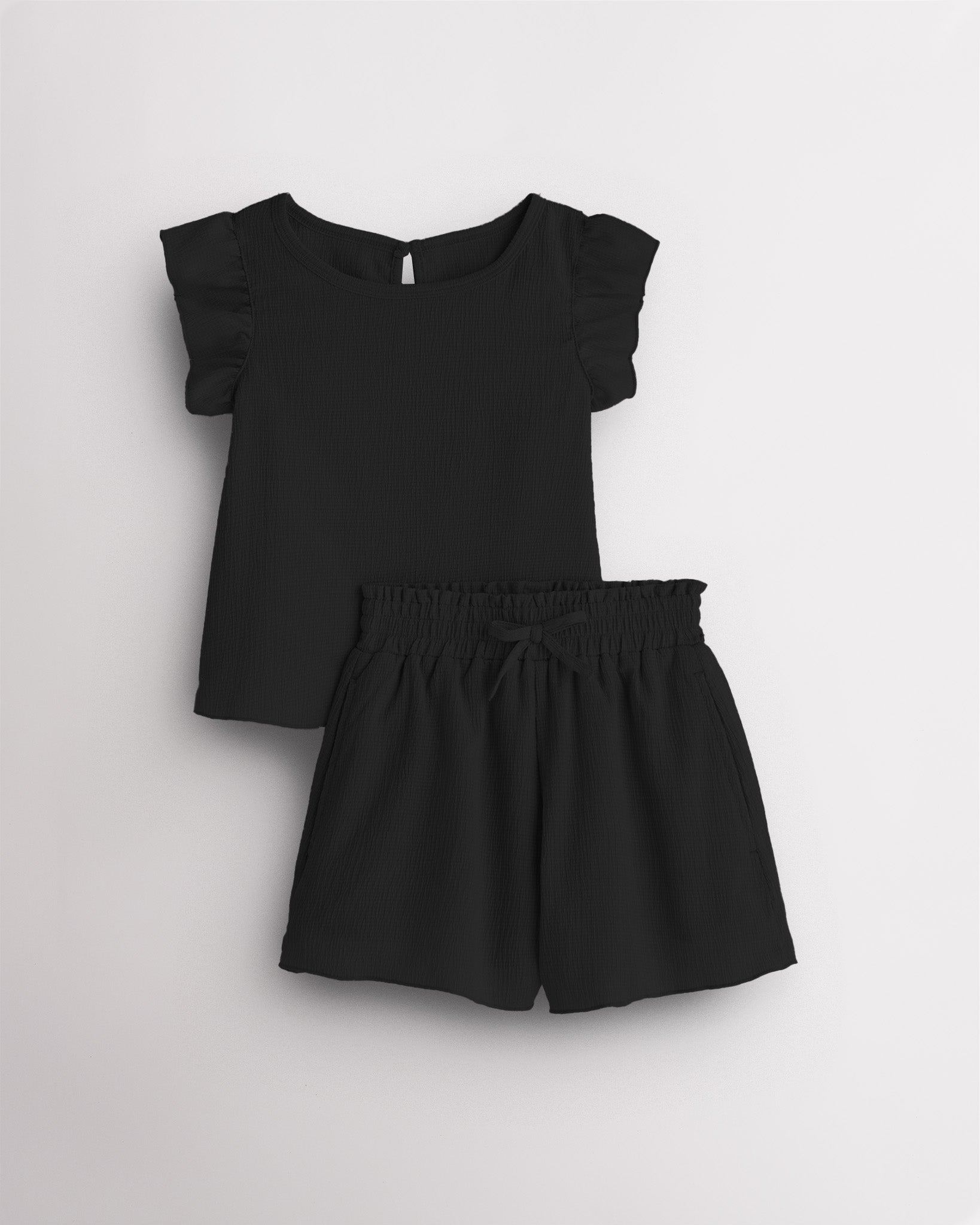 Girls black flutter sleeve summer outfit set with textured top, button-back detail, and matching elastic waist shorts with bow.