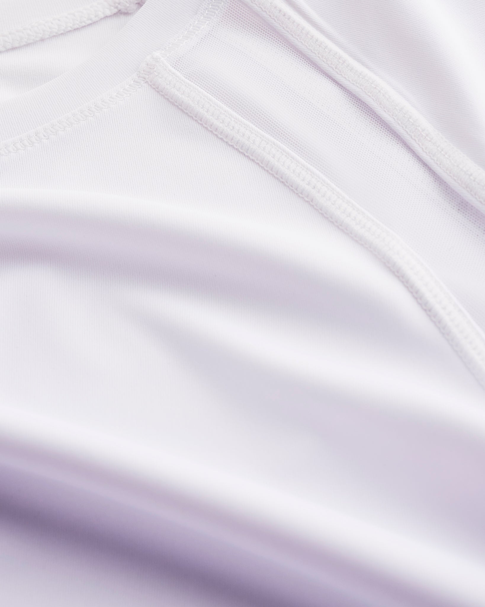 Close-up of Stelle kids ombre athletic t-shirt showing white mesh paneling, smooth seams, and lavender gradient fabric.