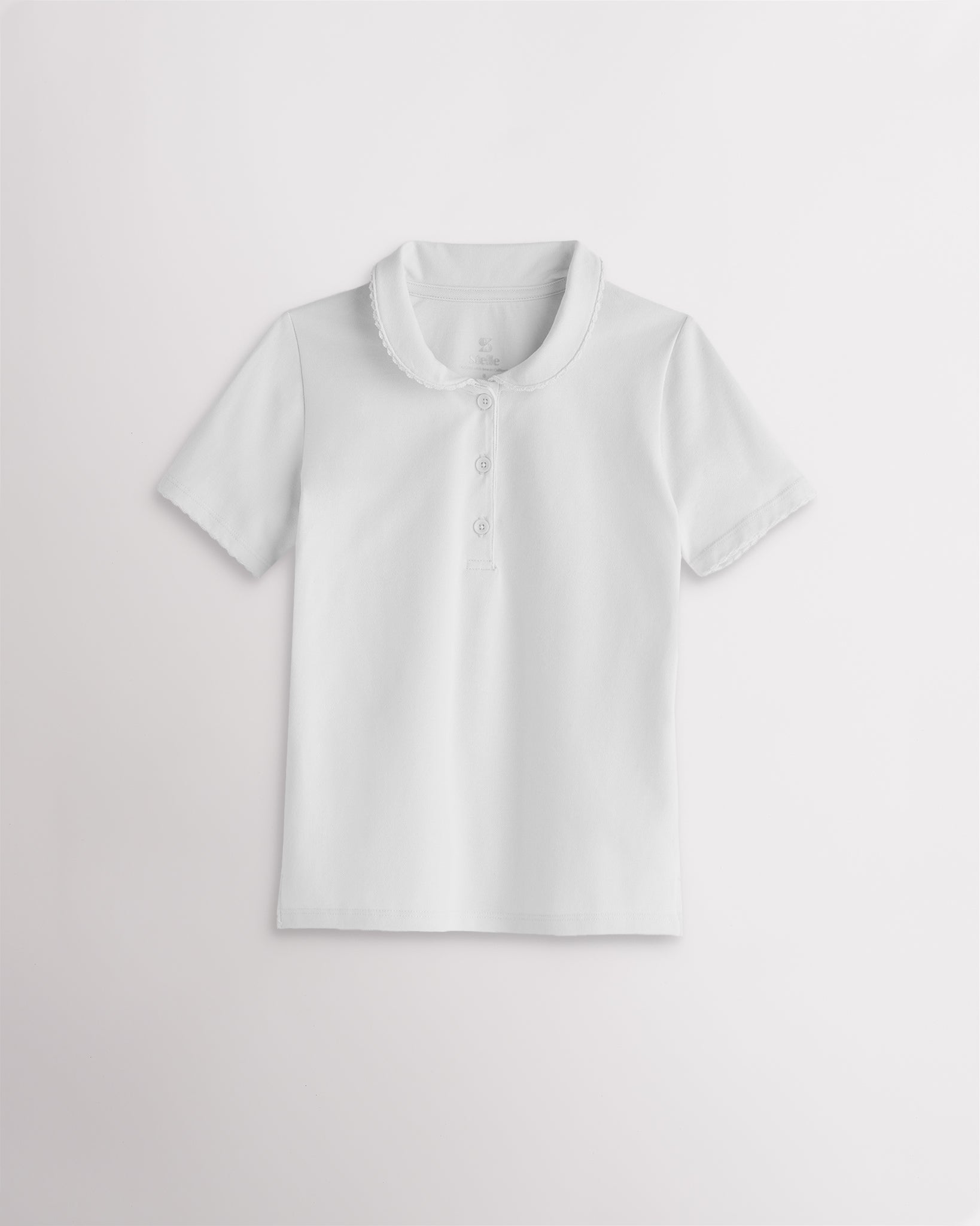 Girls white short sleeve pique polo shirt with a Peter Pan collar, scalloped trim, front button placket, and regular fit.