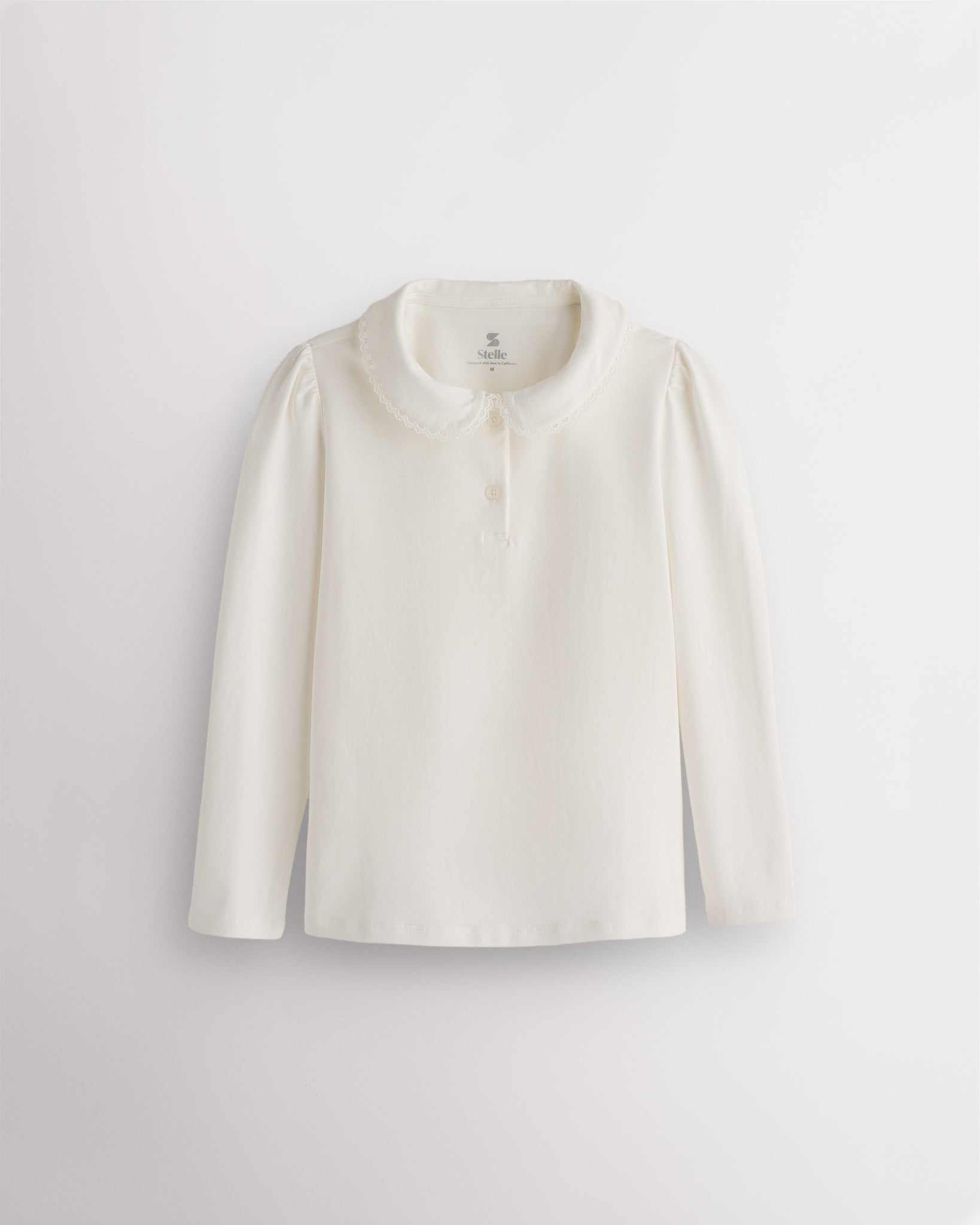 White girls Peter Pan collar long sleeve top with lace trim, subtle puffed shoulders, and two-button placket.