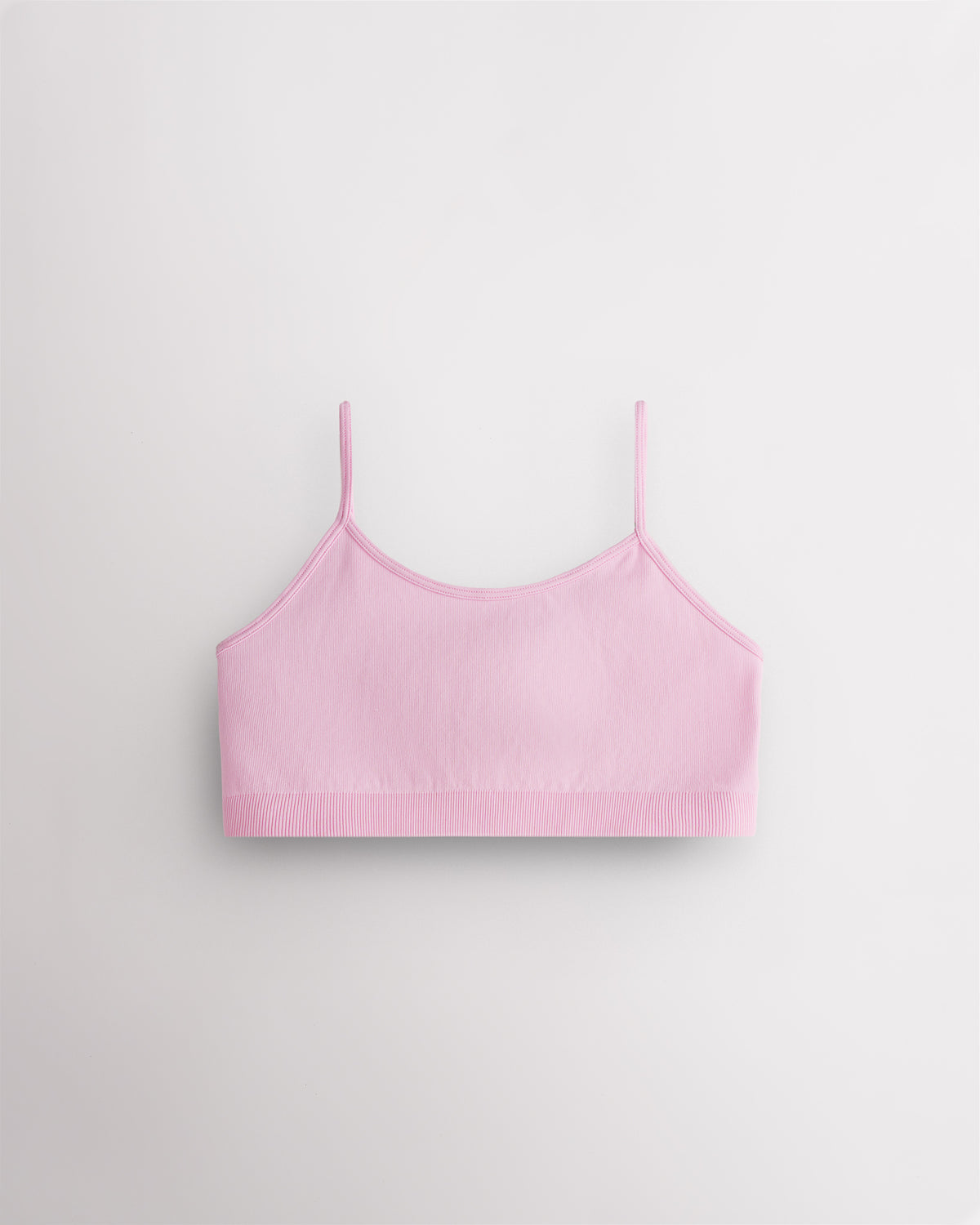 Petal pink Stelle girls seamless cami bra with thin adjustable straps, shown flat.