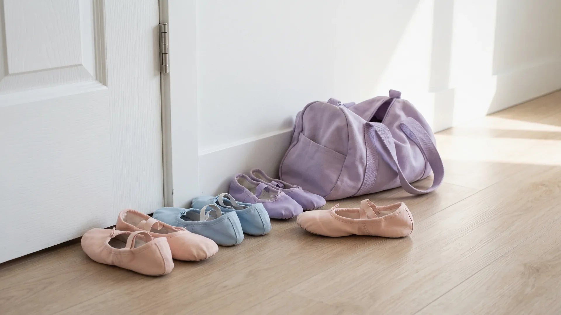 Tiny ballet shoes lined up by a studio door before a toddler ballet class