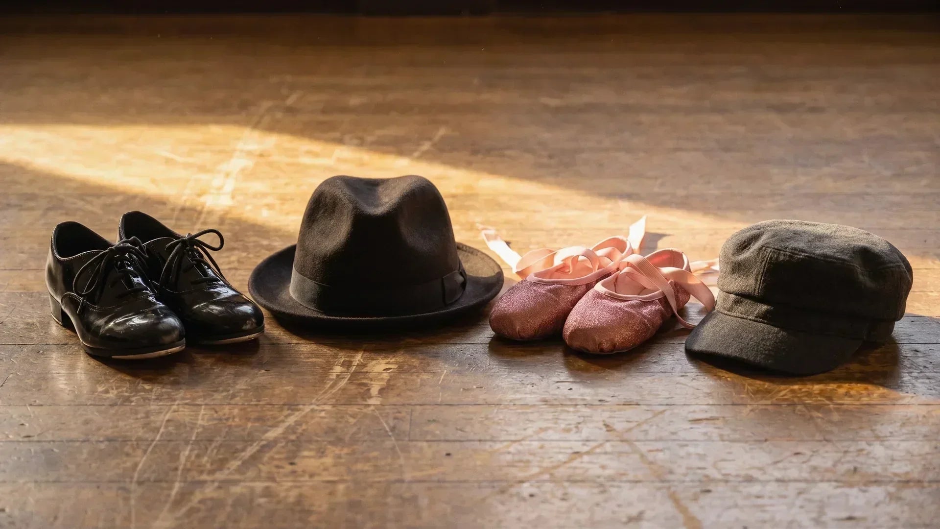 Tap shoes, pointe shoes, fedora and cap representing famous dancers across styles