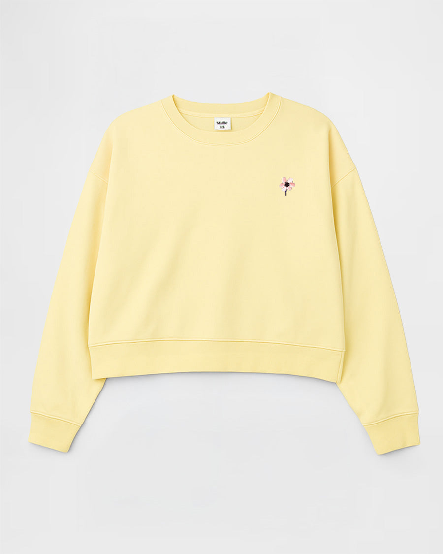 Yellow sweatshirt with a small logo on a light gray background