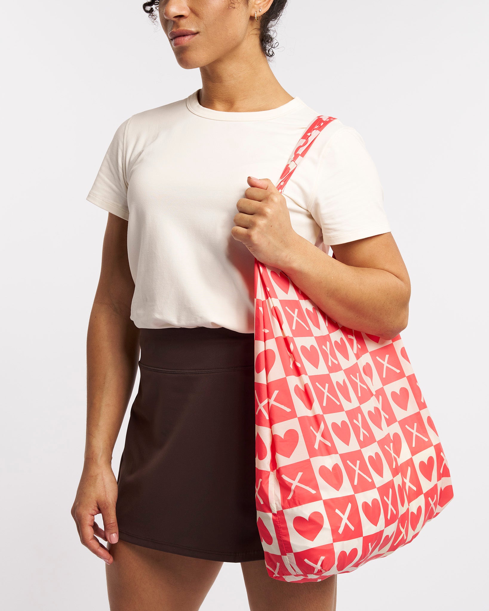 Model carrying Love Match Stelle reusable grocery bag with puppy print over the shoulder, a lightweight foldable bag for markets and errands.