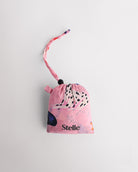 Folded Puppy Parade on Pink Stelle reusable grocery bag in attached pouch with puppy print and clip-on loop for compact storage.