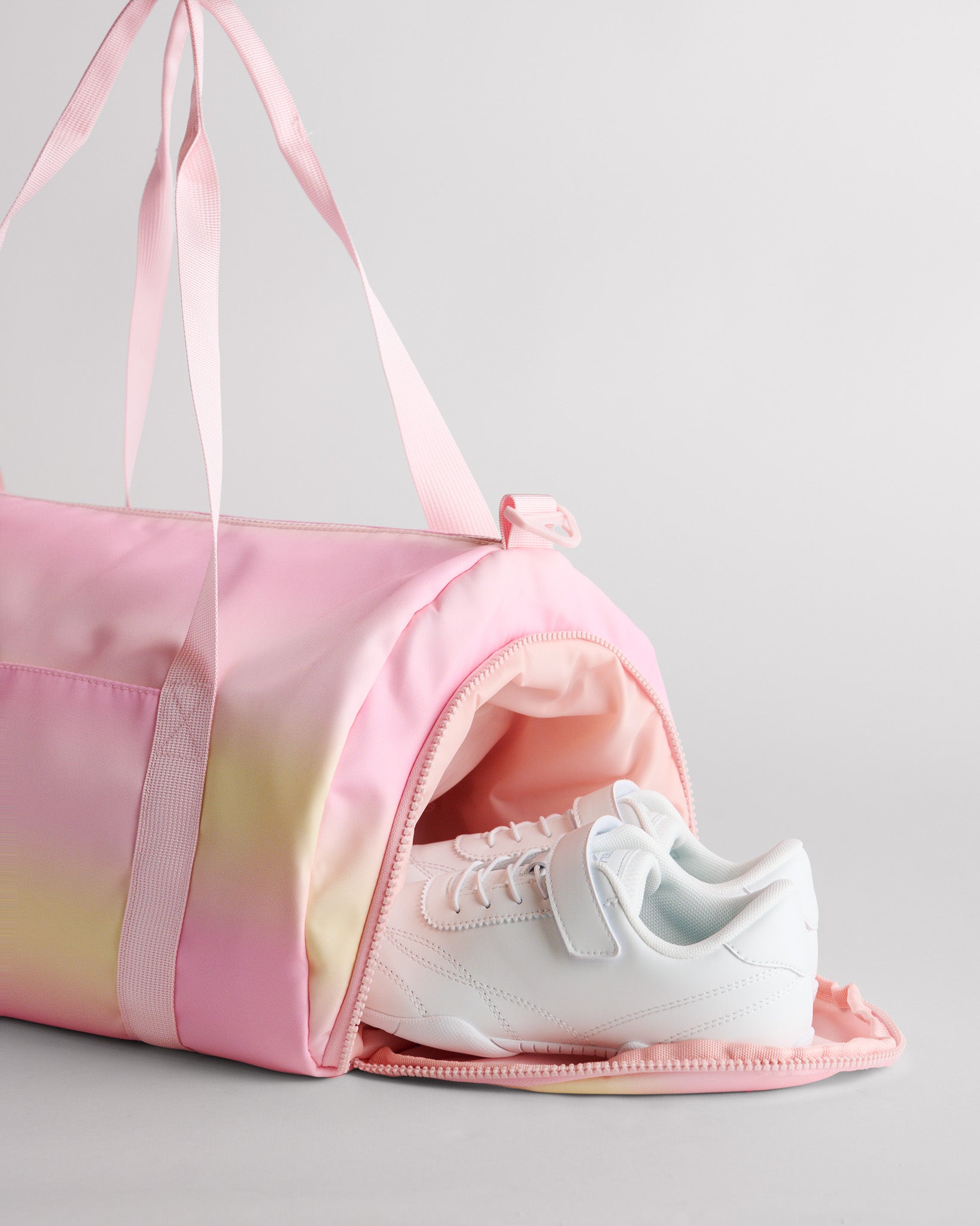 Gym duffle bag with separate shoe compartment holding sneakers for clean and organized packing