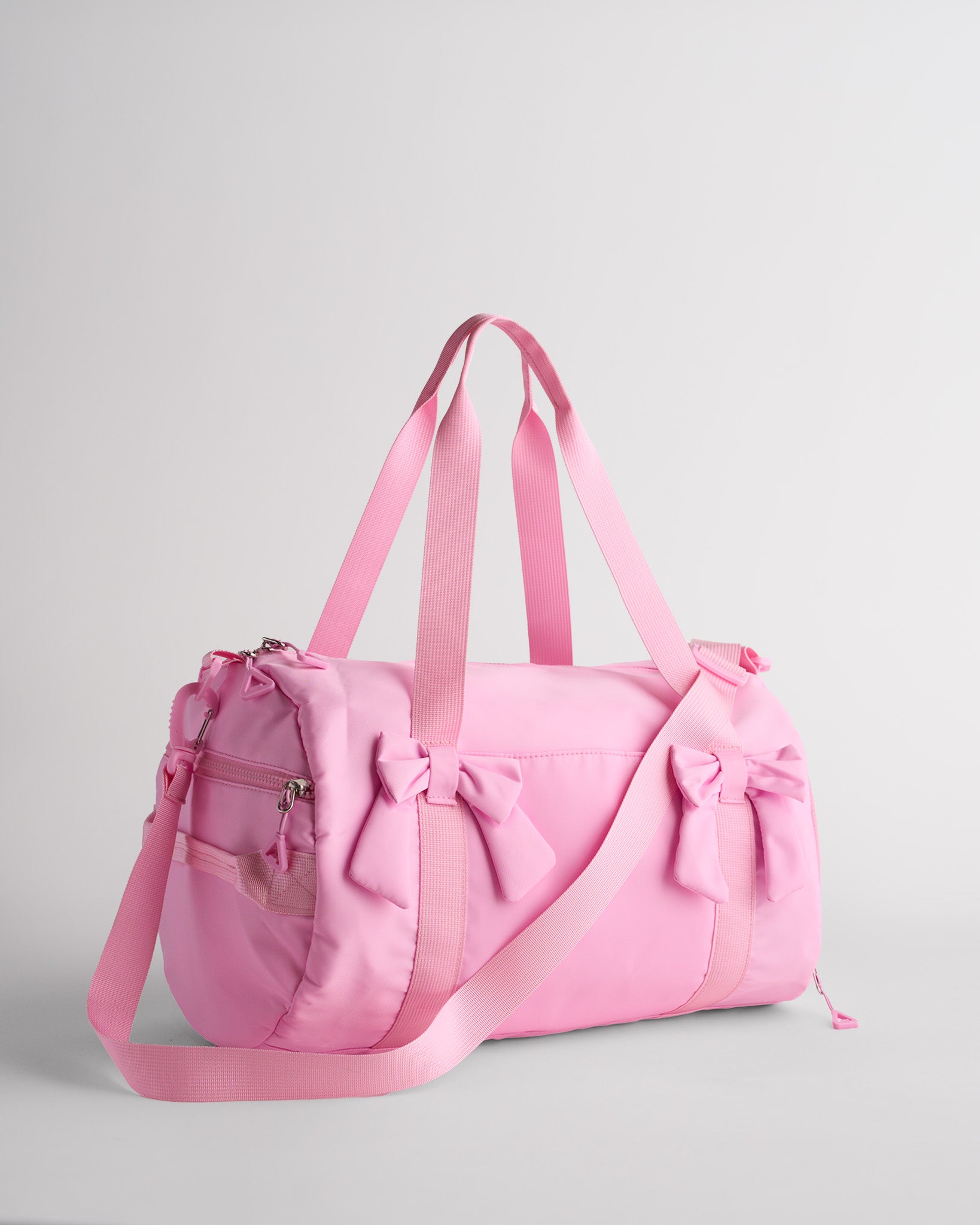 Taffy Pink kids duffle bag with bow details, top handles and adjustable shoulder strap for dance and travel.