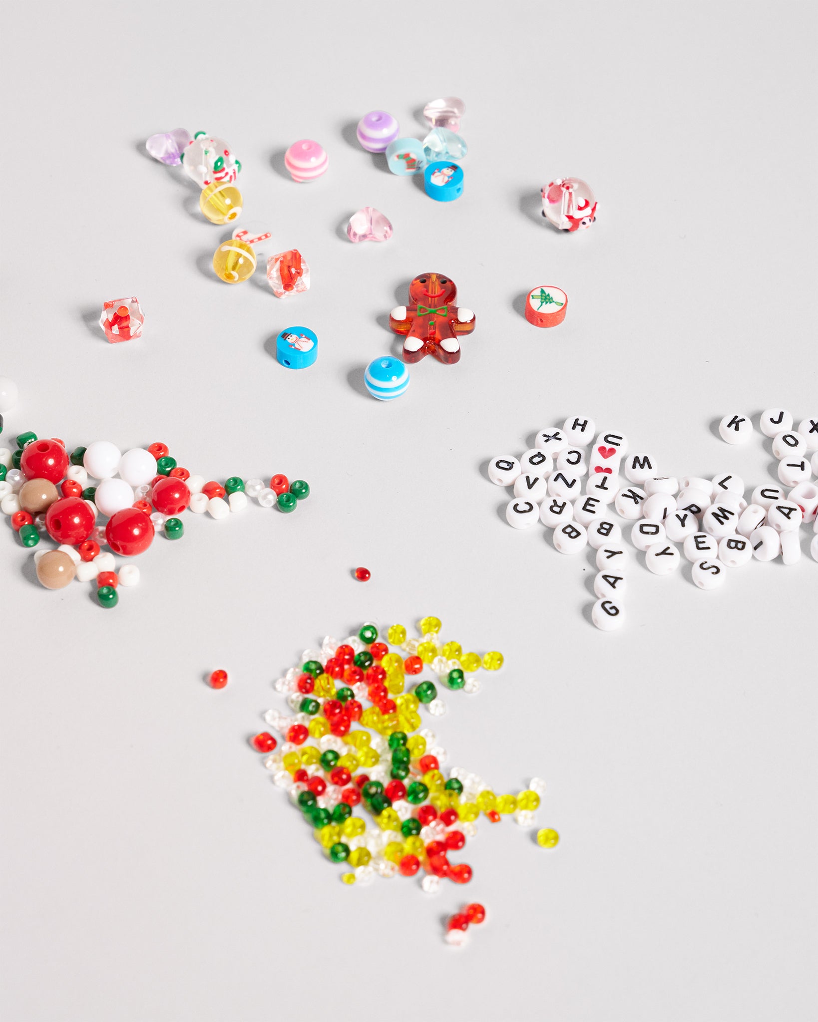 Colorful beads and letters scattered on a light gray background