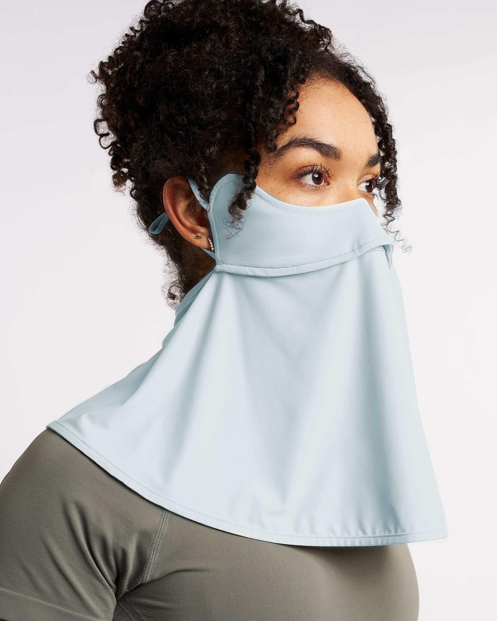 Woman wearing a Light Blue UPF 50+ sun protection face mask with full neck coverage, adjustable ear loops, and secure back fit.