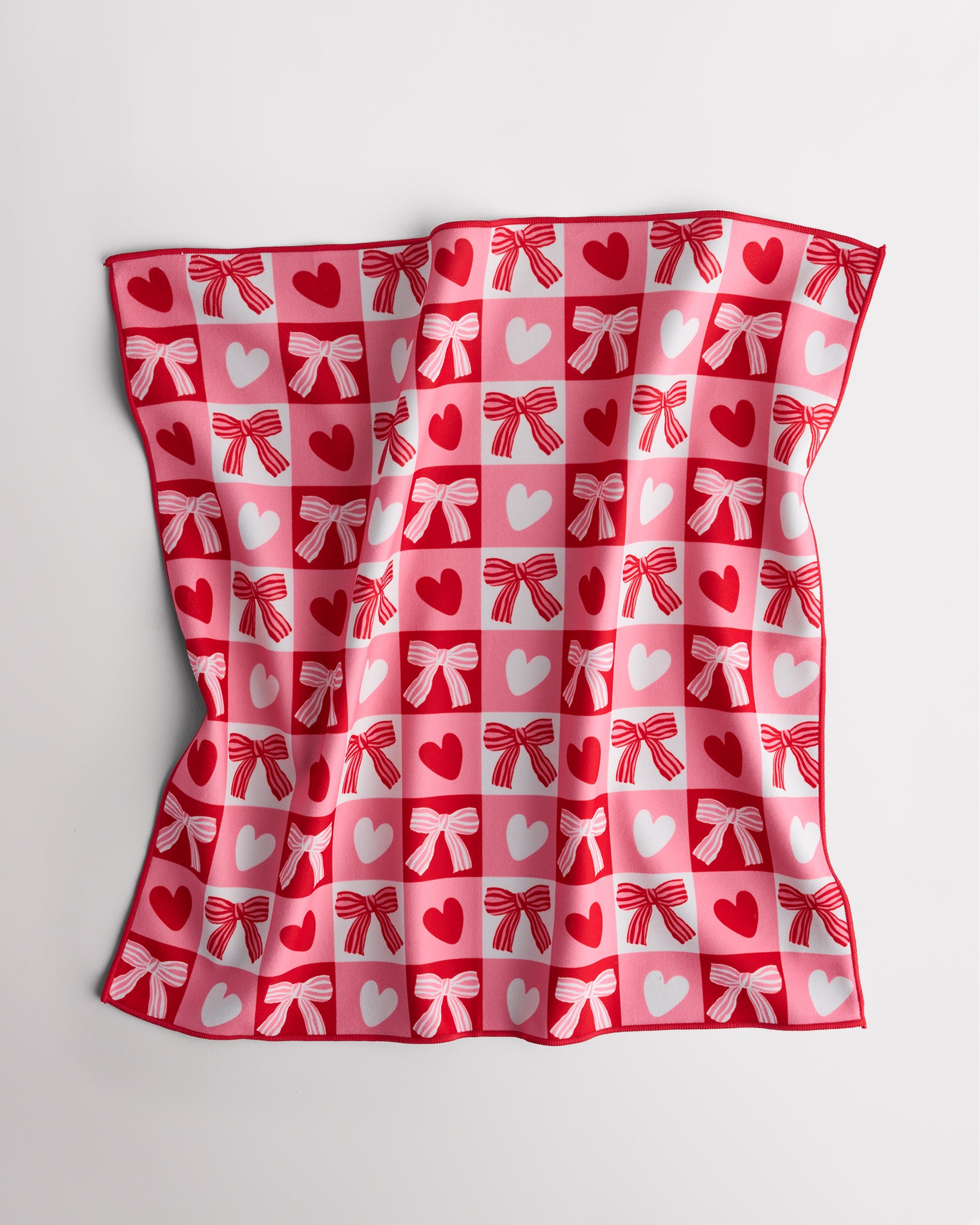 Magic Self-Adhesive Wrapper Essential Bag with red and pink heart and bow print, shown slightly folded