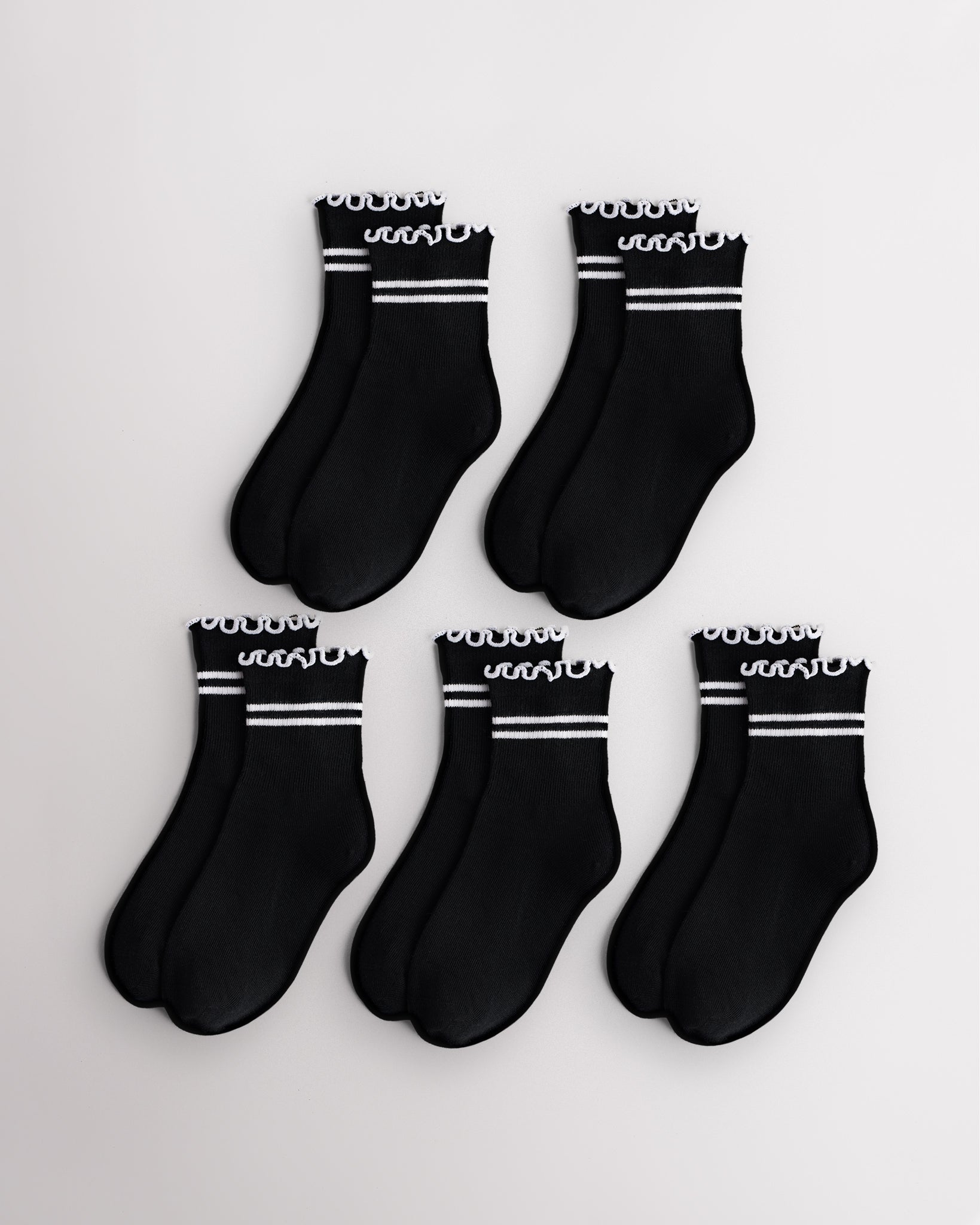 Five pairs of black kids socks with white sporty stripes and lettuce-edge ruffle cuffs