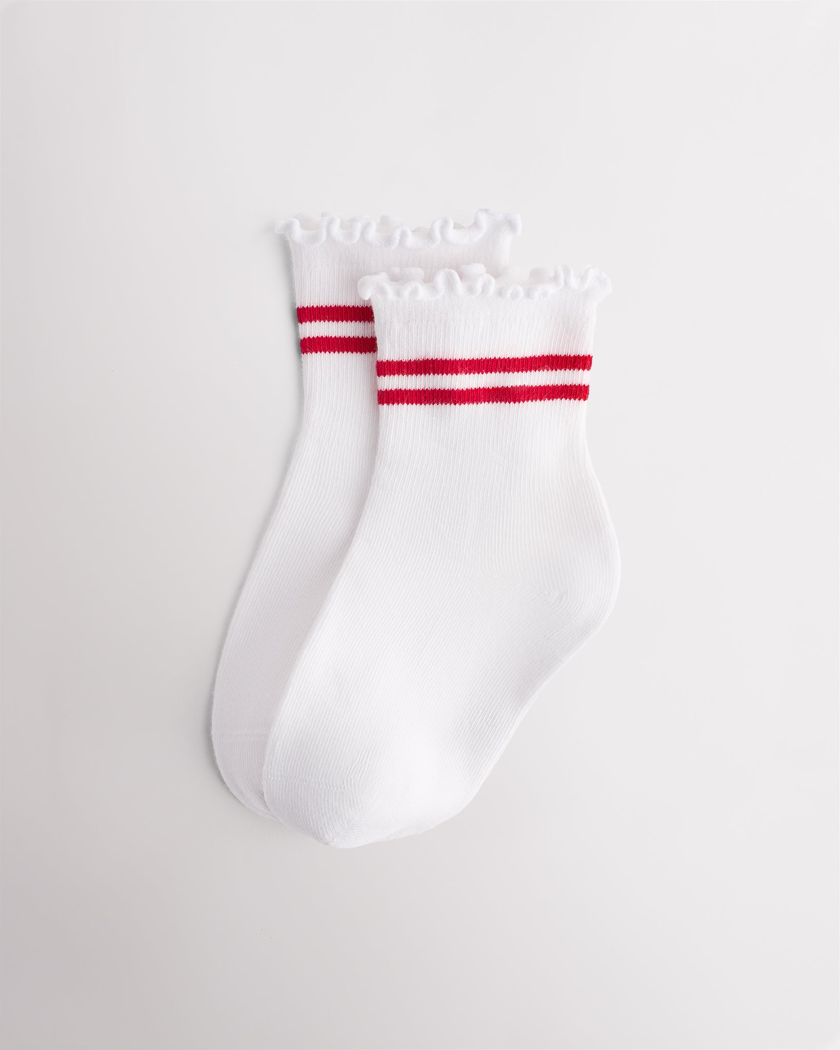 White kids socks with red sporty stripes, ribbed cuffs, and lettuce-edge ruffle trim
