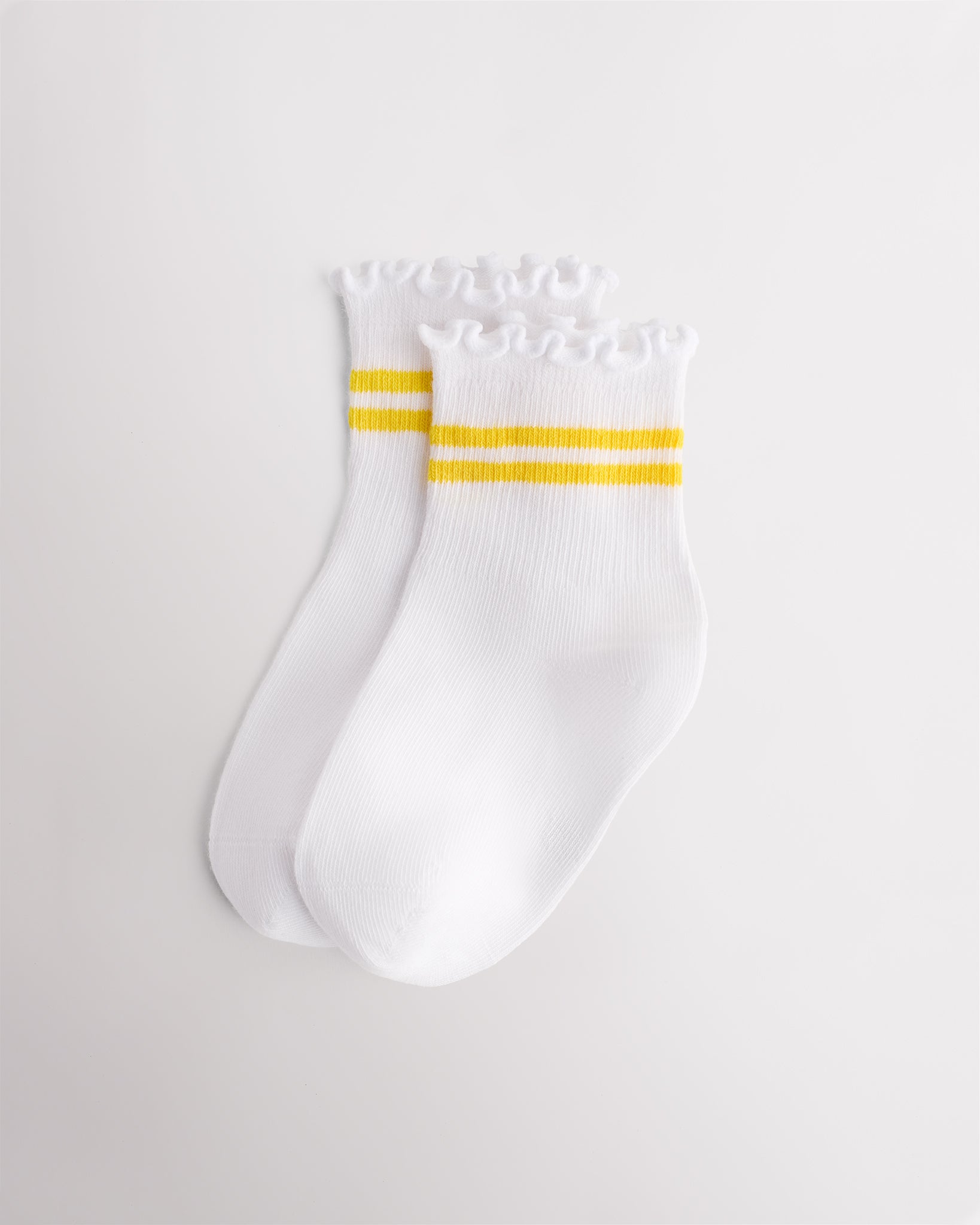 White kids socks with yellow sporty stripes, ribbed cuffs, and lettuce-edge ruffle trim