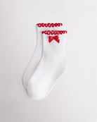 White kids socks with red ribbon bow, red lettuce-edge ruffle cuffs, and ribbed texture