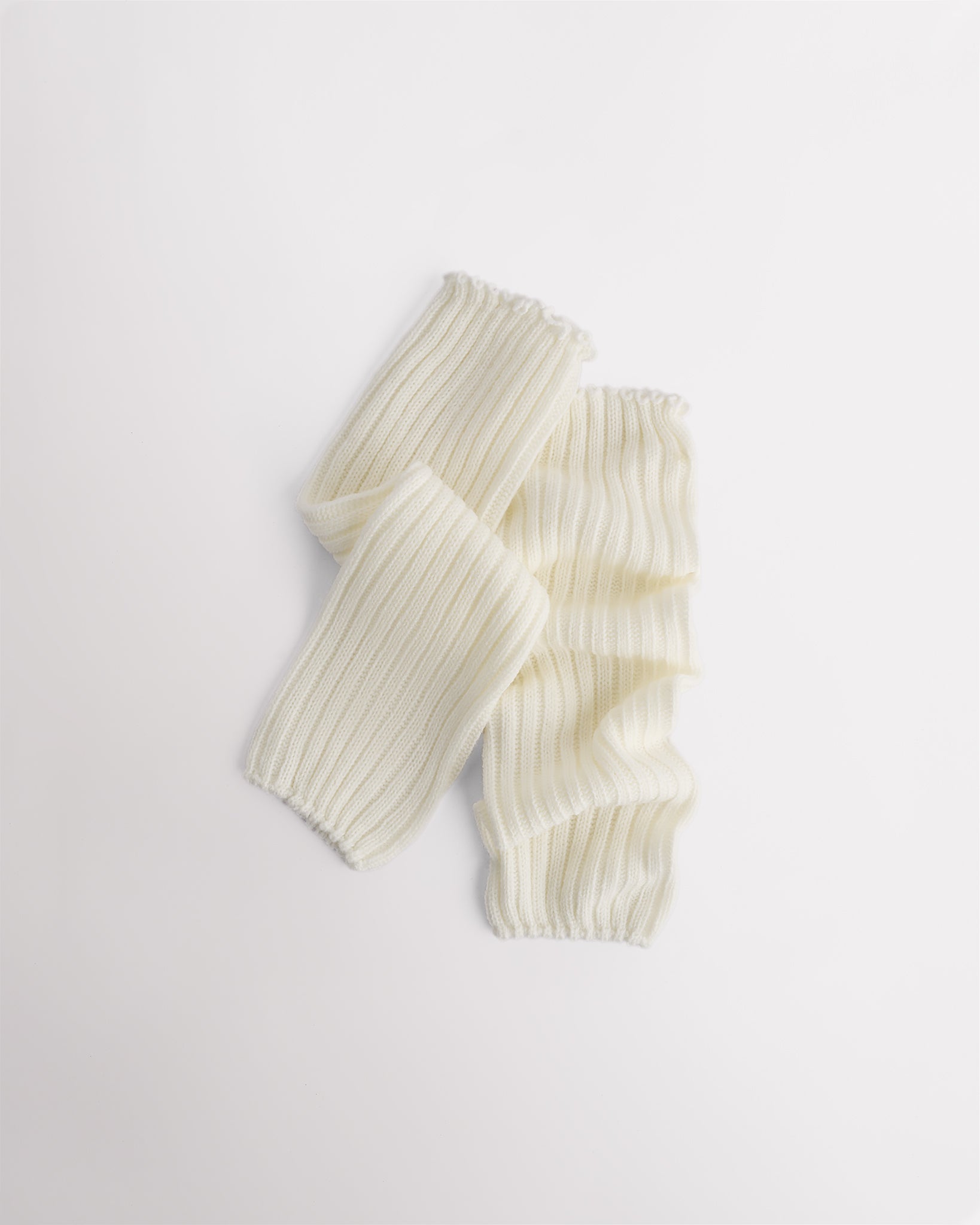 Creme knit kids ballet leg warmers laid flat with a fitted shape and ribbed texture.