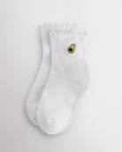 White kids ruffle socks with avocado embroidery, lettuce-edge trim, ribbed crew length, and soft everyday fit.