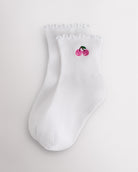 White kids ruffle socks with cherry embroidery, lettuce-edge trim, ribbed crew length, and shaped heel.