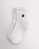 White kids ruffle socks with strawberry embroidery, lettuce-edge trim, ribbed crew length, and everyday wear design.