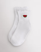 White kids ruffle socks with watermelon embroidery, lettuce-edge trim, ribbed crew length, and shaped heel.