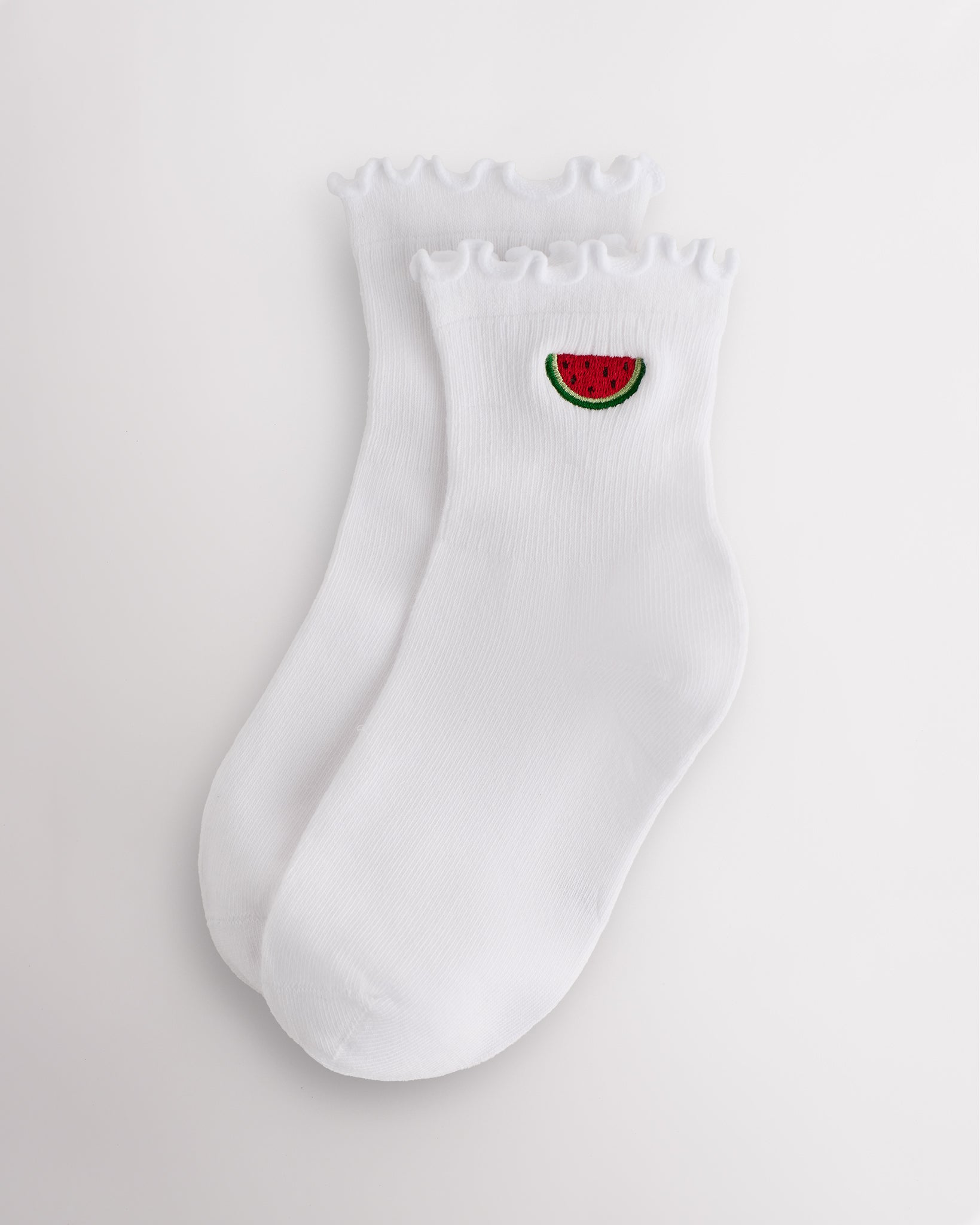 White kids ruffle socks with watermelon embroidery, lettuce-edge trim, ribbed crew length, and shaped heel.