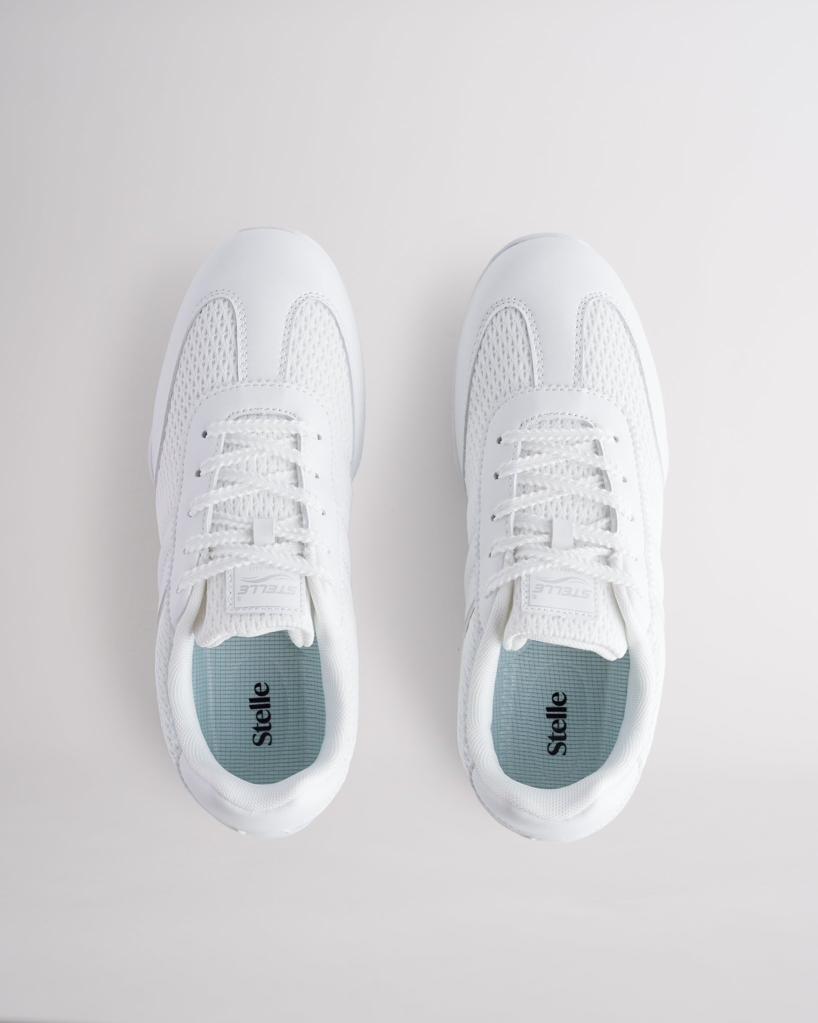 White Studio air mesh cheer shoes with lace-up closure.