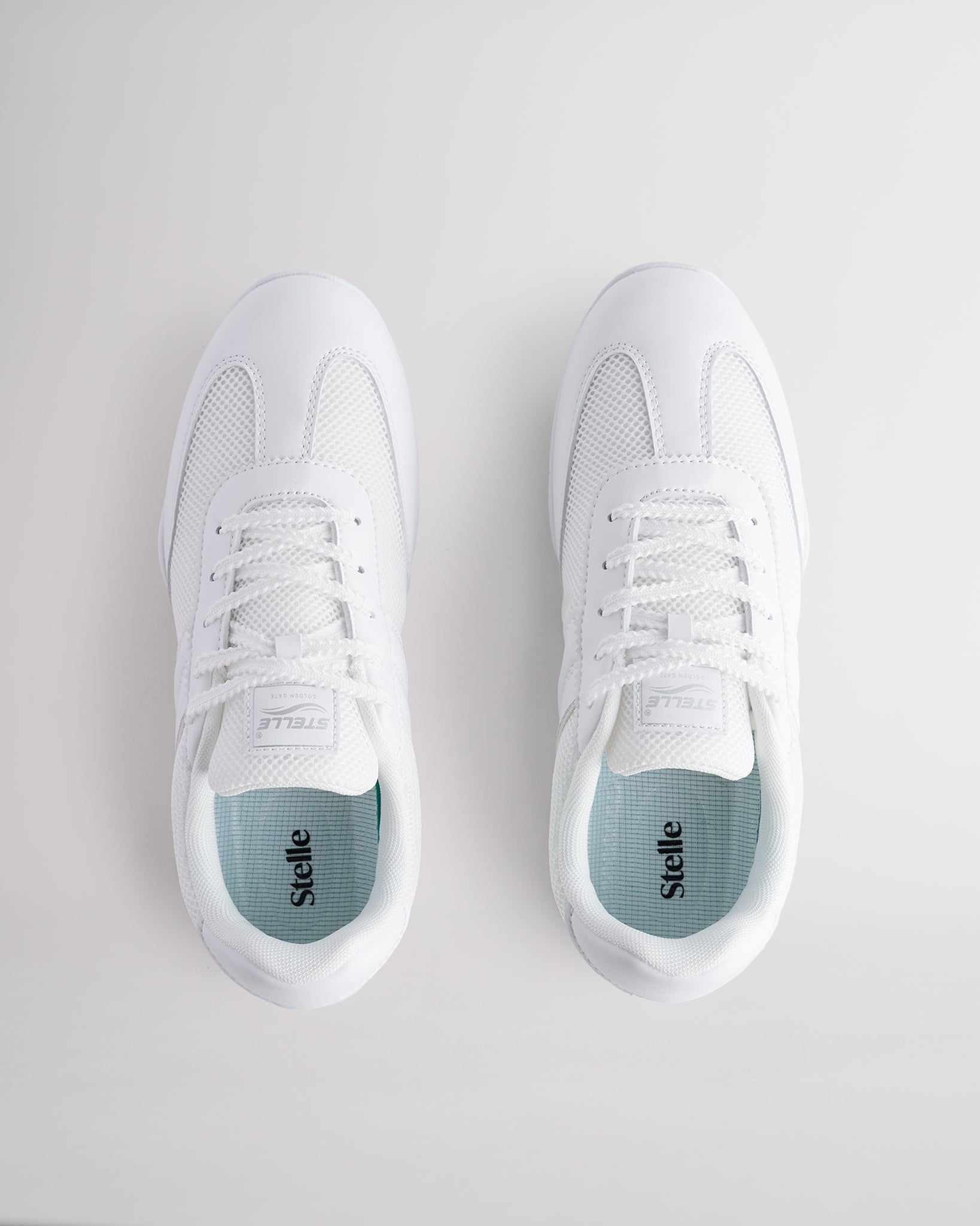 White Studio fine mesh cheer shoes with lace-up closure.