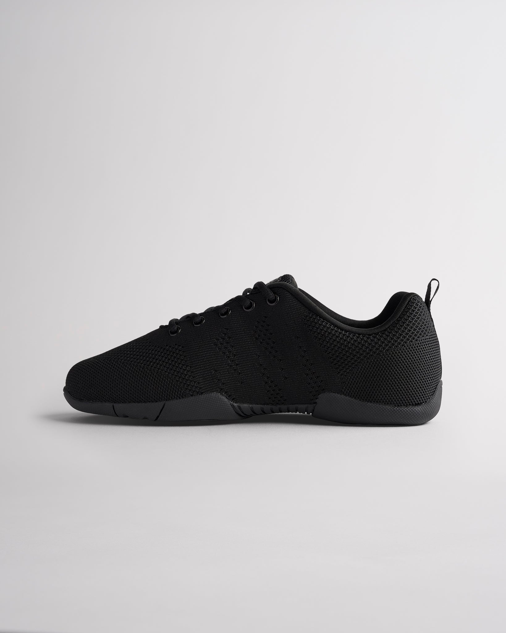 Black cheerleading shoes with lace-up design and adaptive knit upper for secure fit