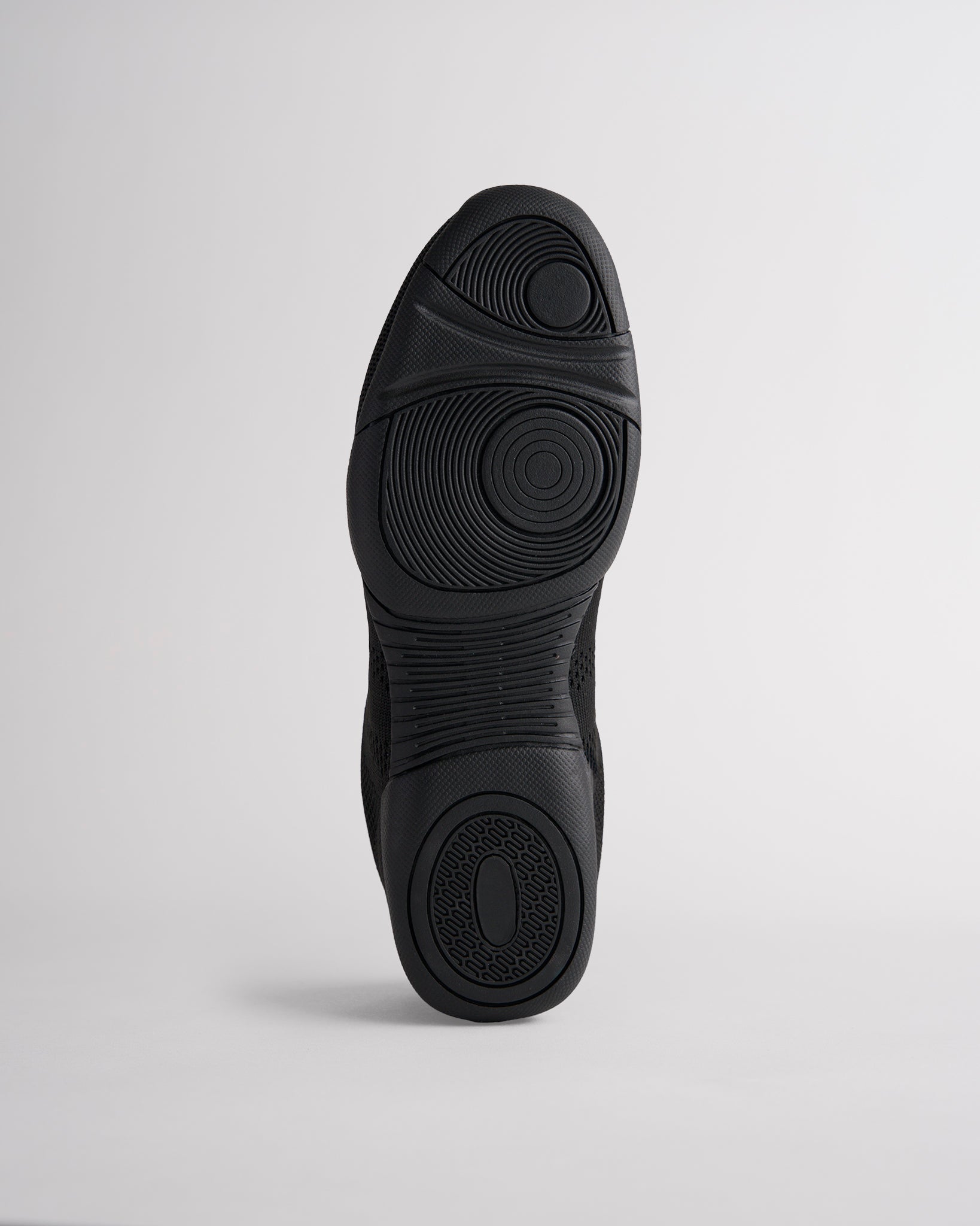 Bottom view of black cheer shoes showing textured sole with reliable traction pattern