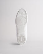 Bottom view of white cheer shoes showing textured sole with reliable traction pattern