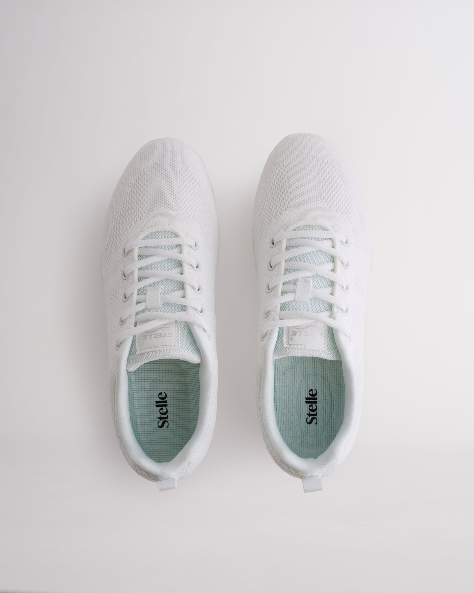 Top view of white womens cheer shoes with lace-up closure and cushioned interior
