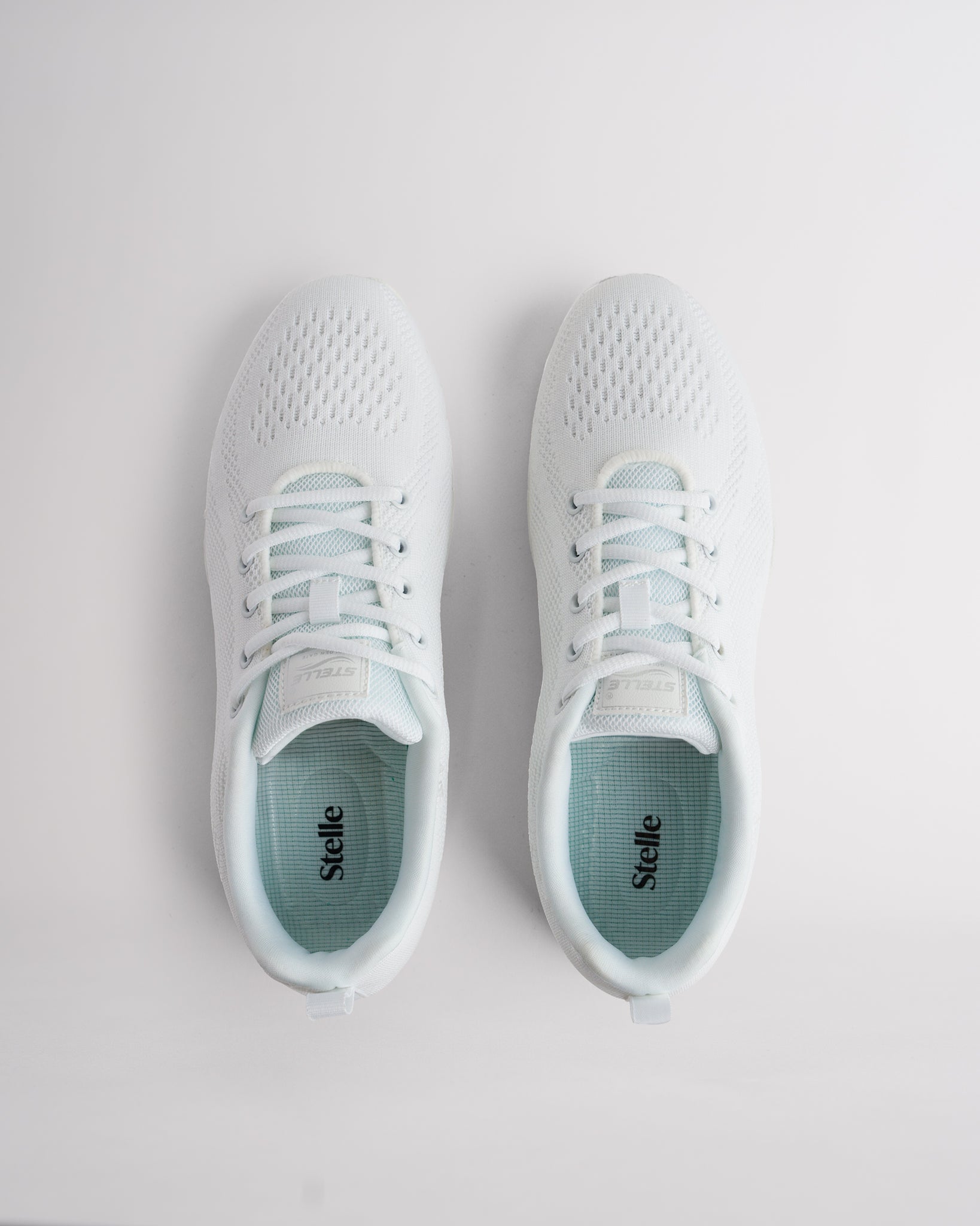 Top view of white cheer shoes with lace-up closure and cushioned interior for secure fit