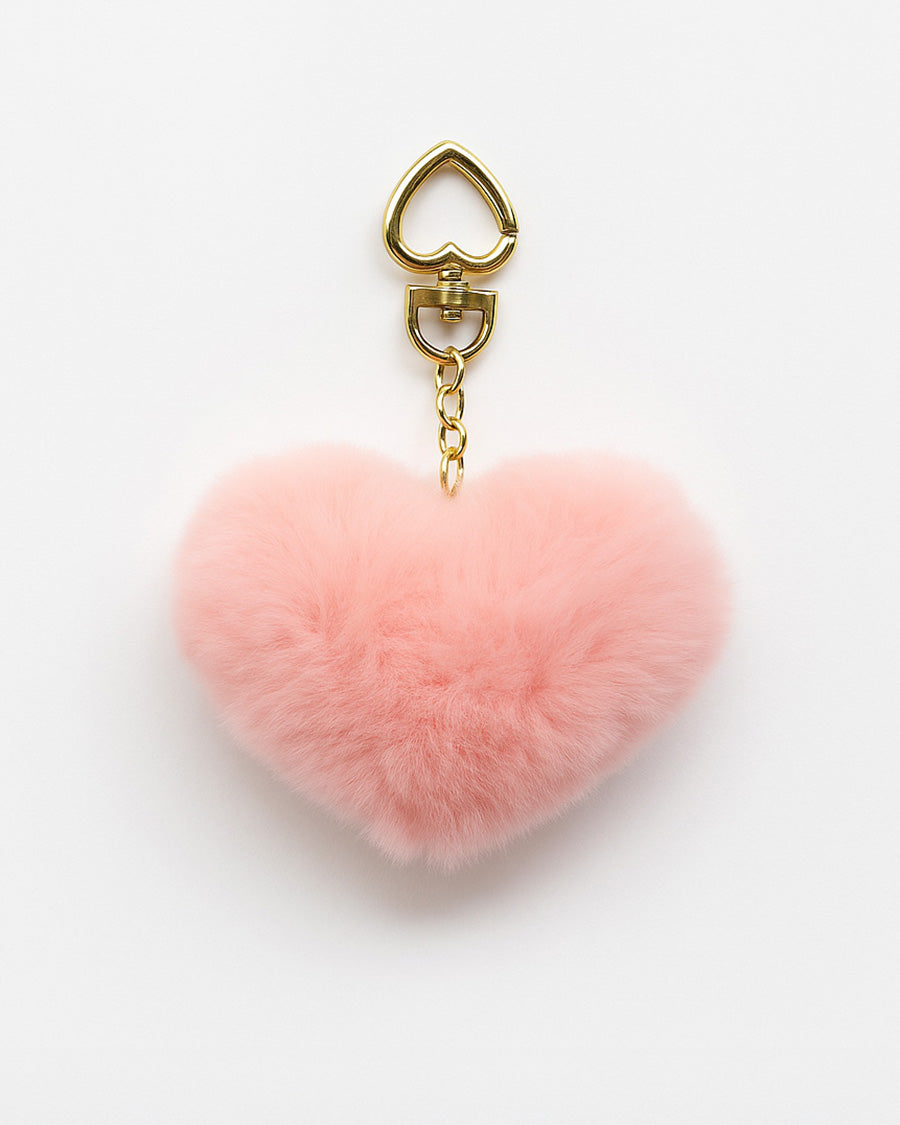 Pink heart-shaped fluffy keychain with a gold clasp on a white background